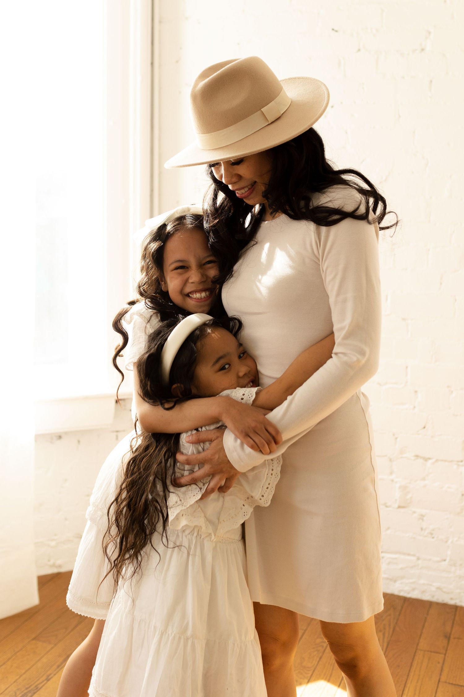 Warm-toned portraits capturing loving moments between subjects in white dresses and a straw hat.