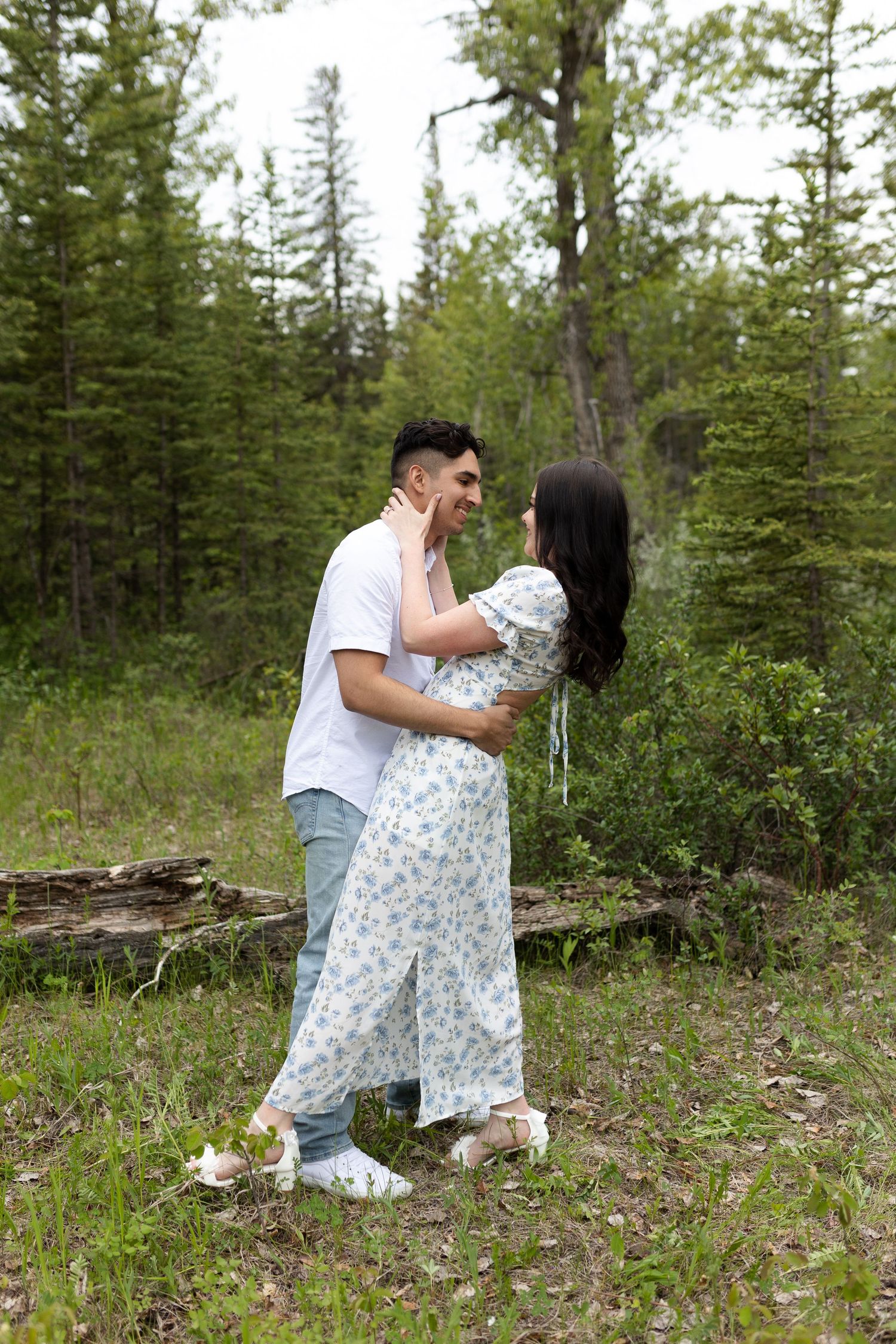 Couple sharing an intimate moment in a forest clearing.