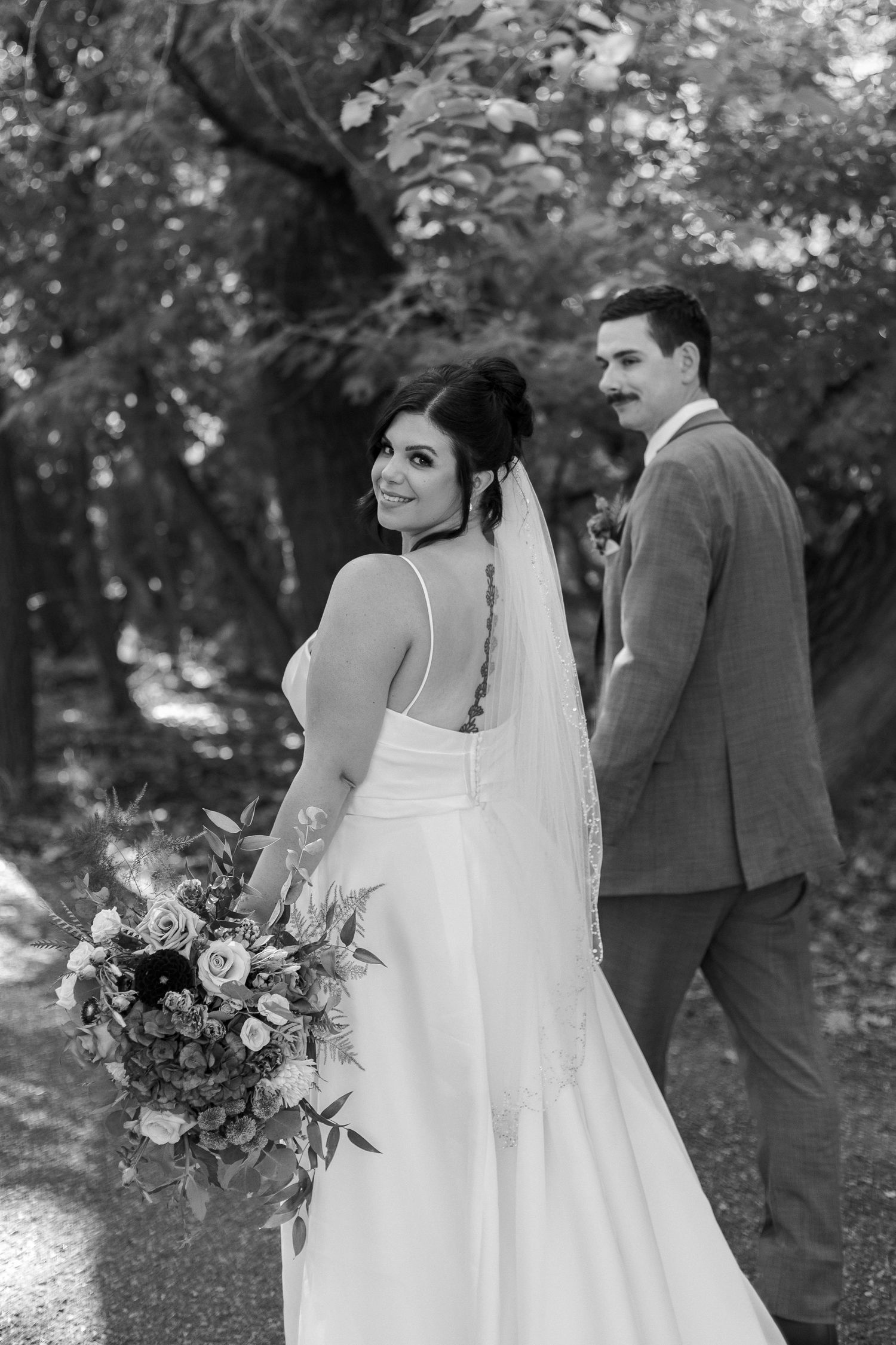 Black and white wedding portraits show romantic moments in garden setting.