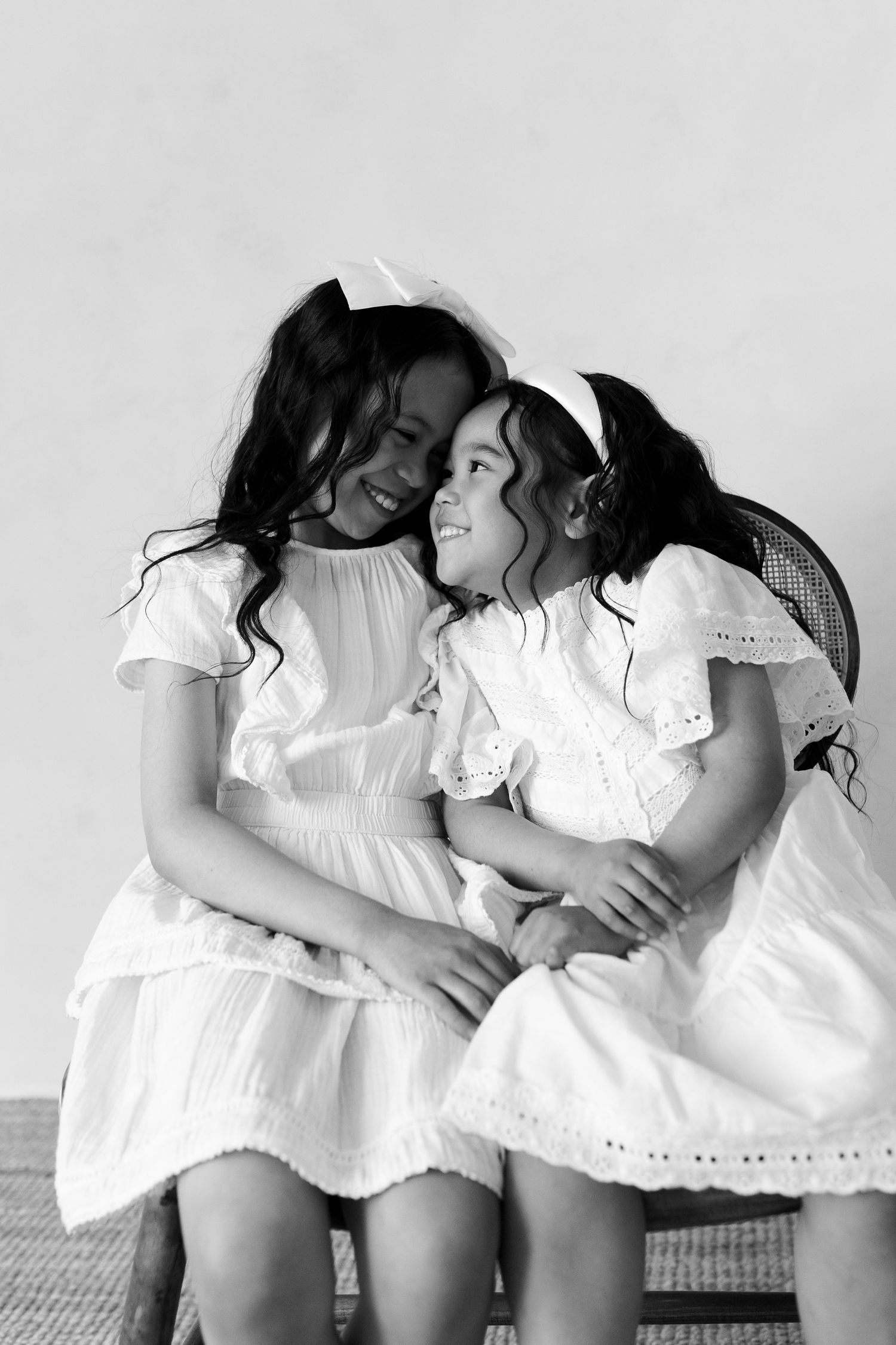 Black and white portraits capturing intimate moments between subjects in matching white outfits.