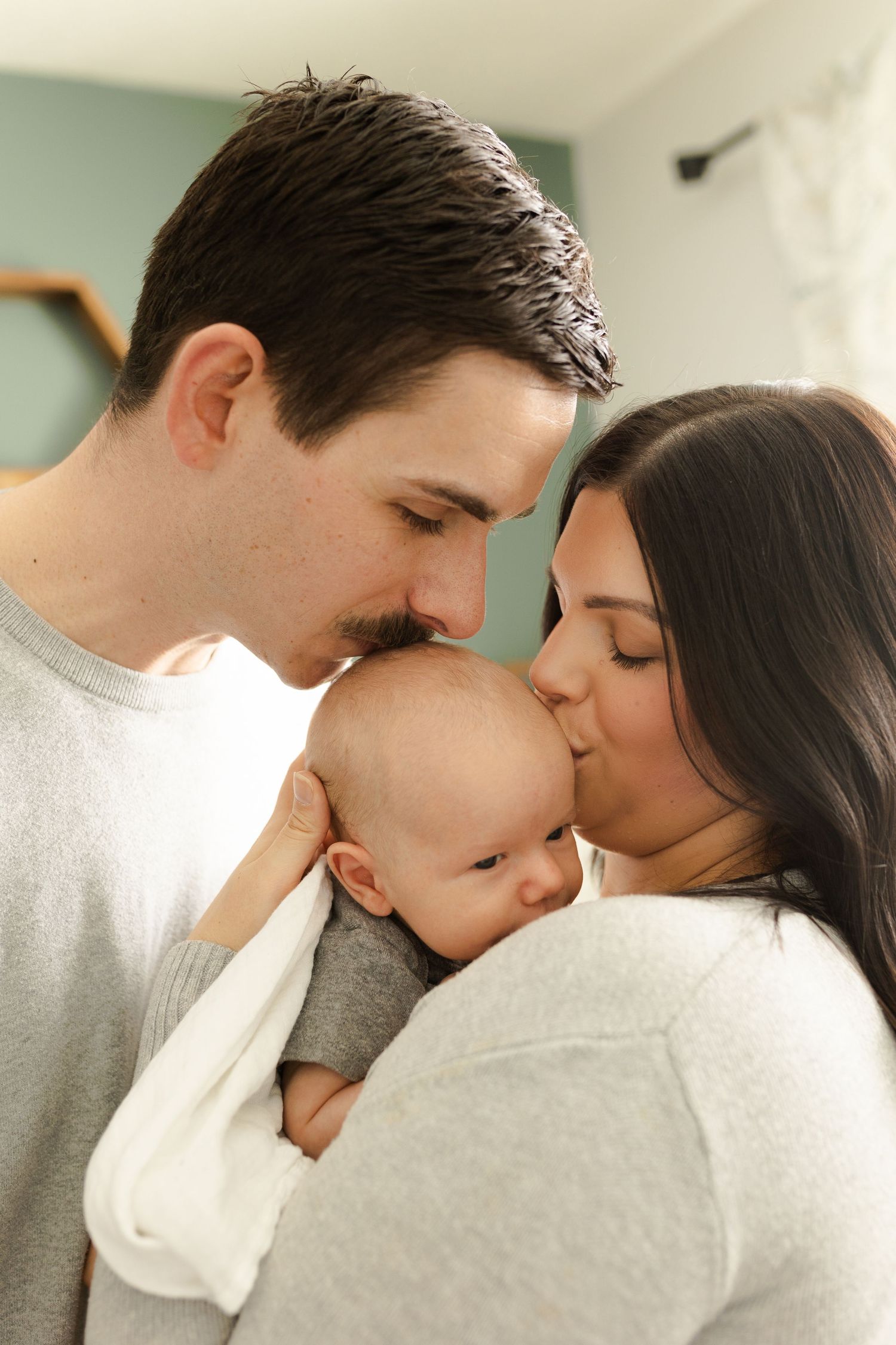 Intimate family portrait series showing tender moments with a newborn.