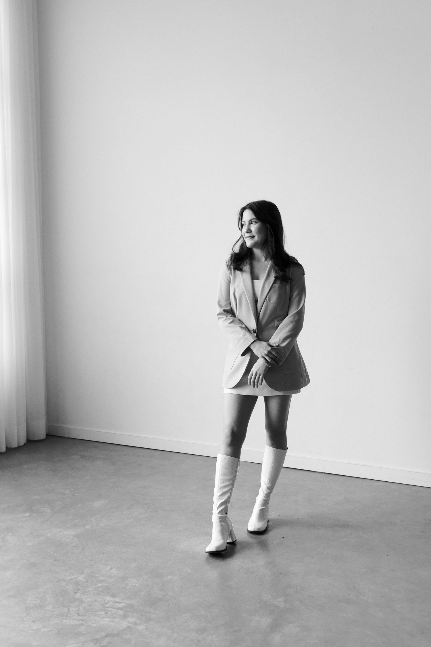 A series of black and white photos showing a person in casual attire performing expressive dance movements against a white wall.