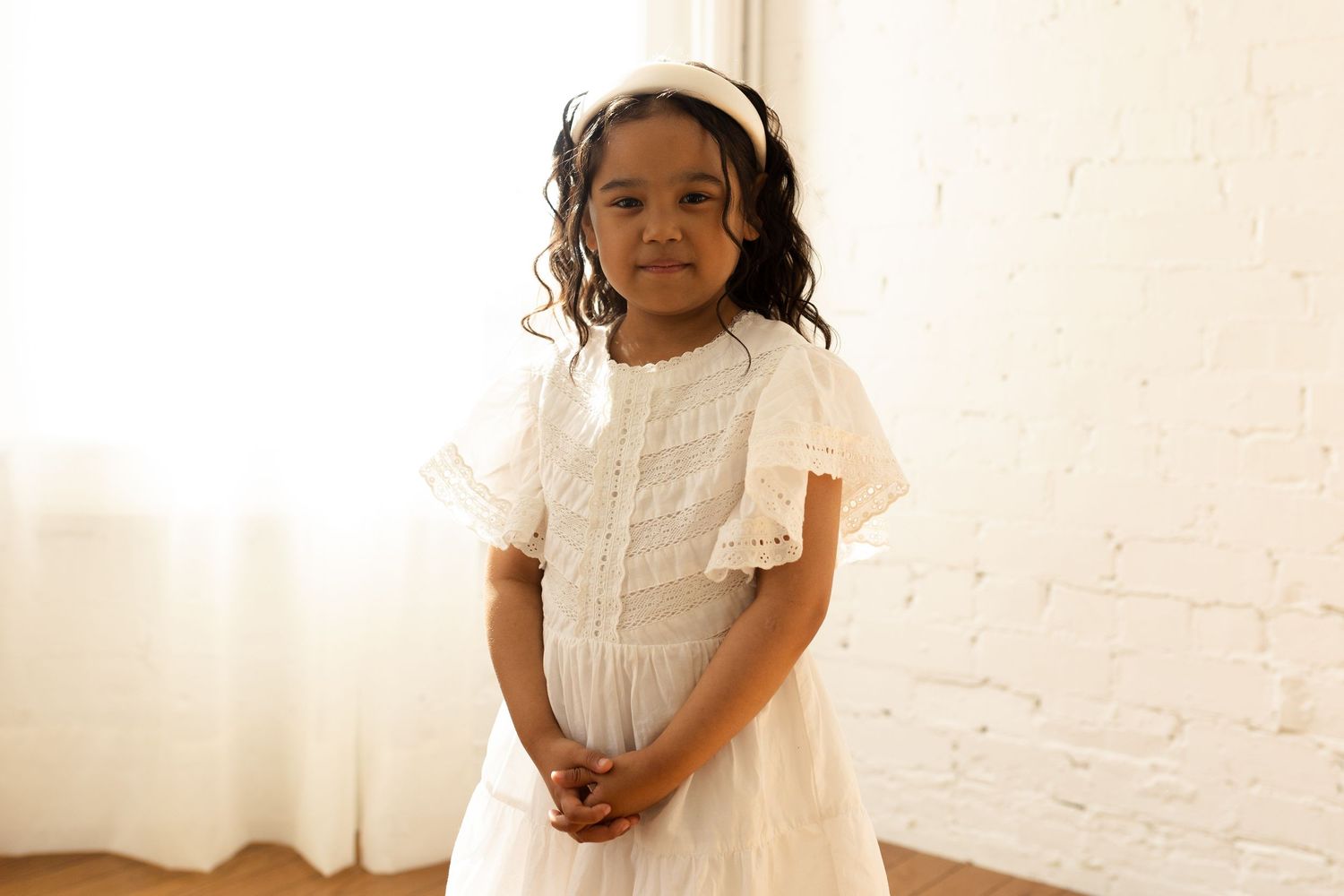 Series of candid shots in white room showing joyful moments in white outfits.