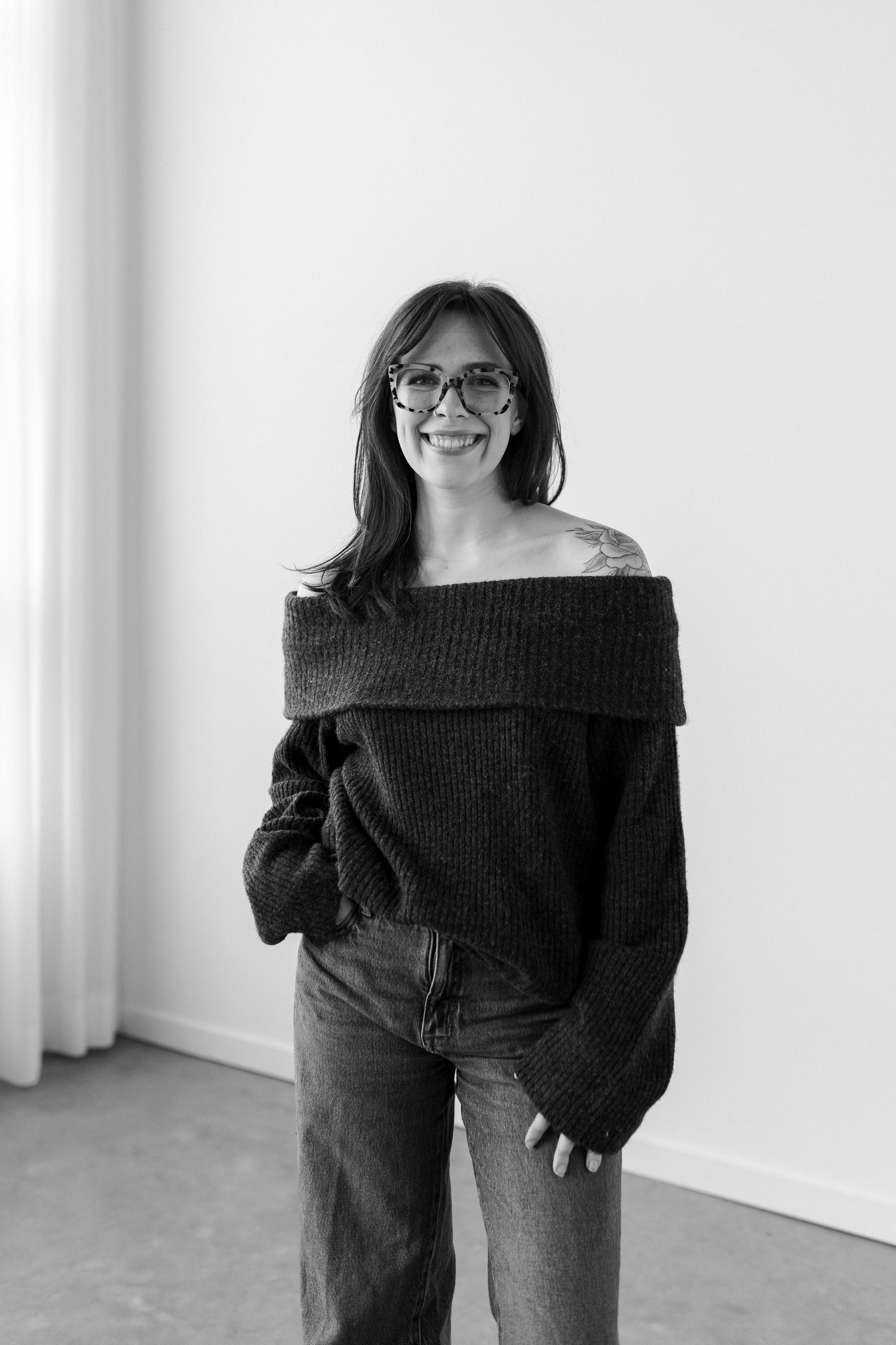 A sequence of four black and white photos showing someone wearing a black sweater in different playful poses.