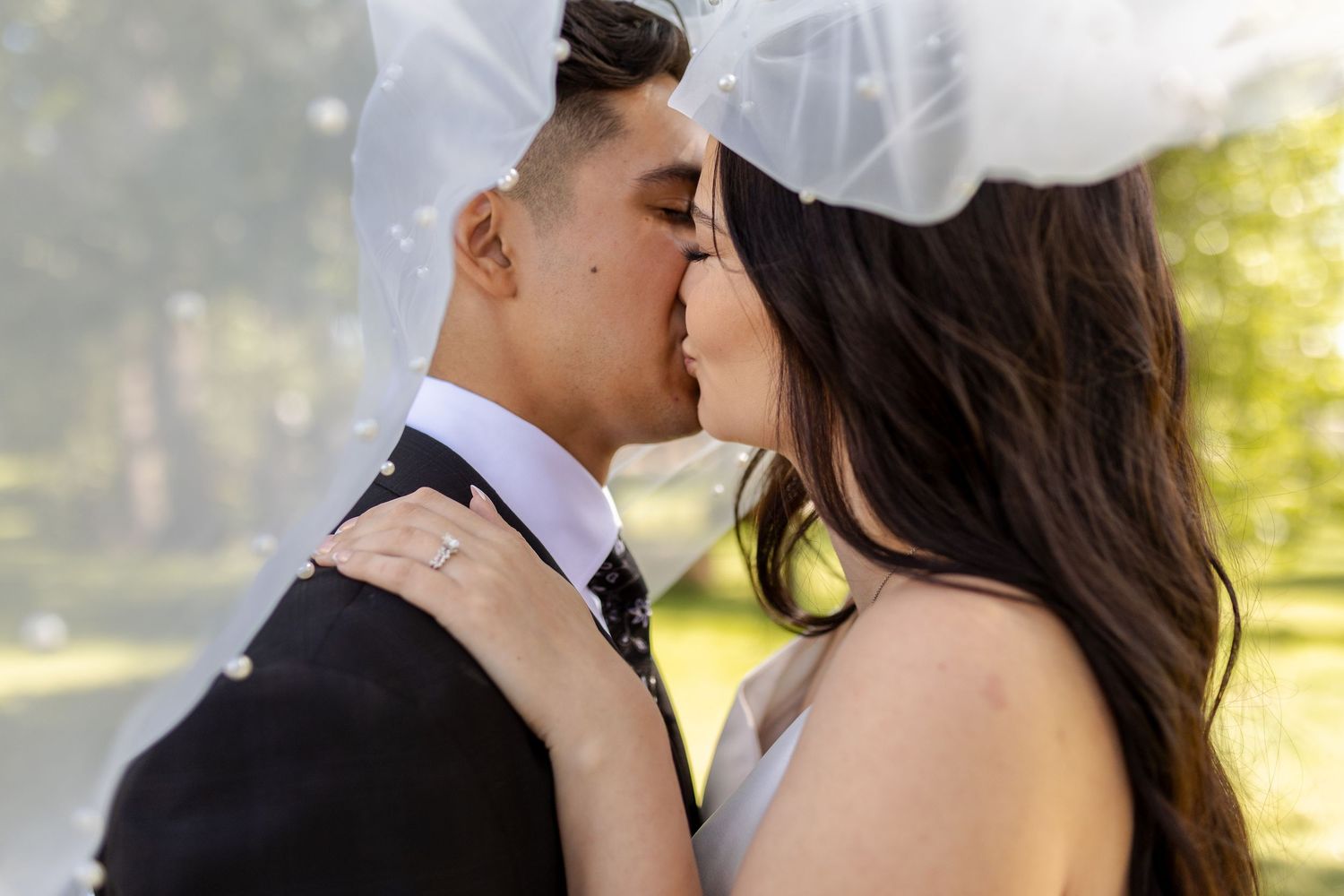 A romantic couple shares intimate moments during their outdoor wedding photo session at sunset.