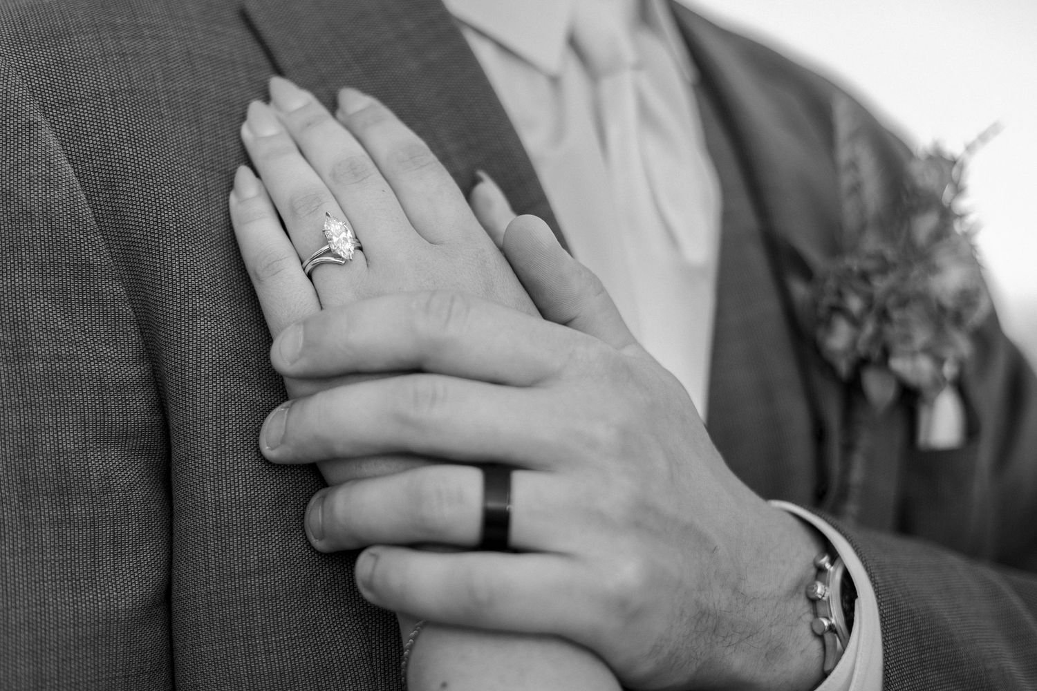 Close-up shots of wedding rings being exchanged during an intimate ceremony in black and white.