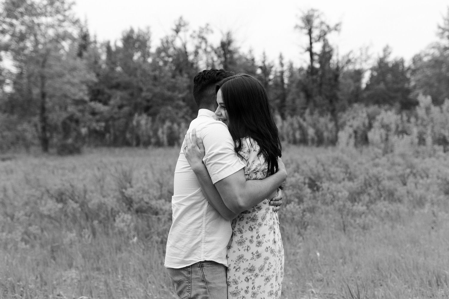Black and white photo of couple sharing tender moment in nature.