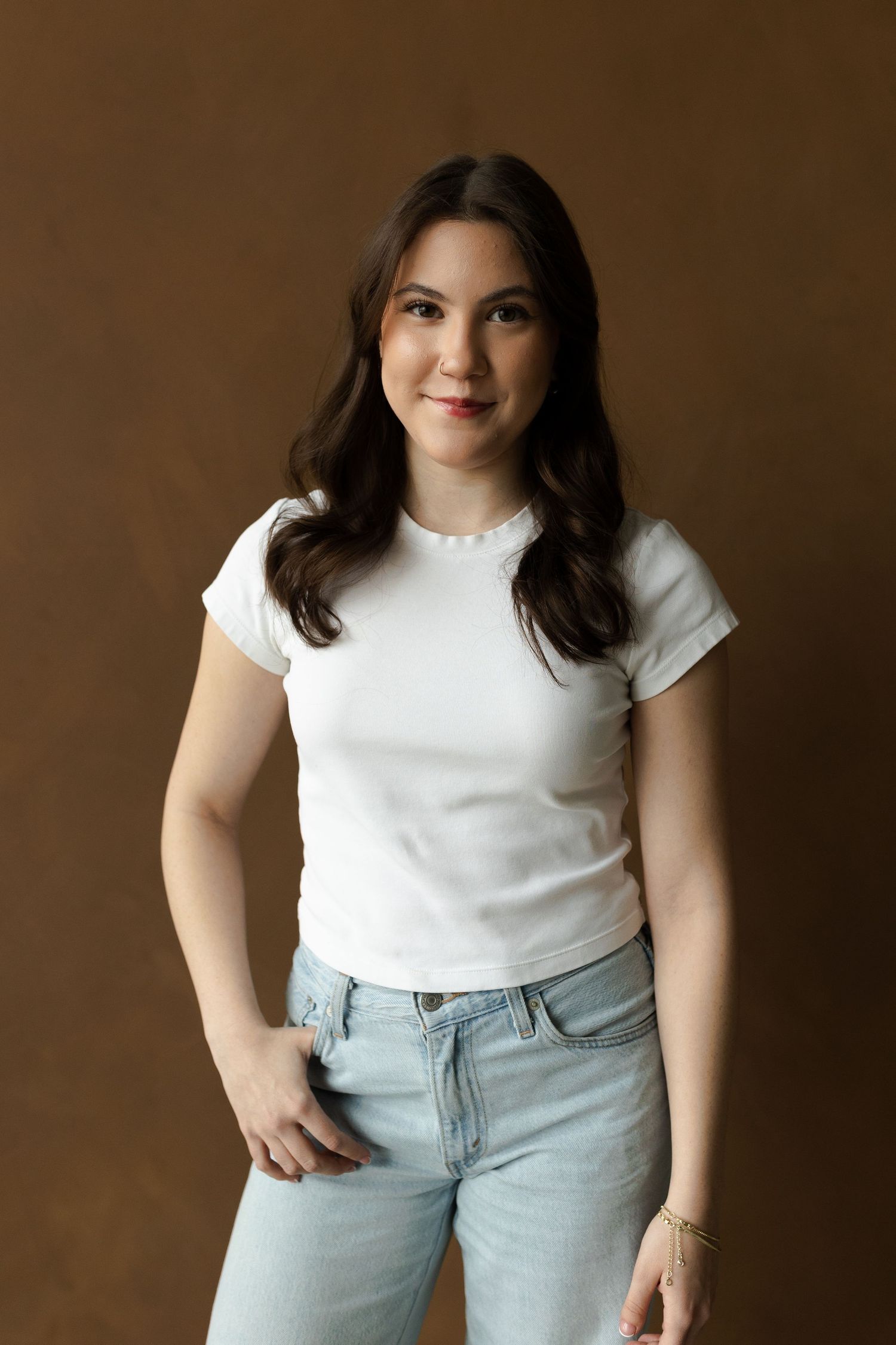 Portrait series showing casual poses in light denim jeans and white t-shirt against brown backdrop.