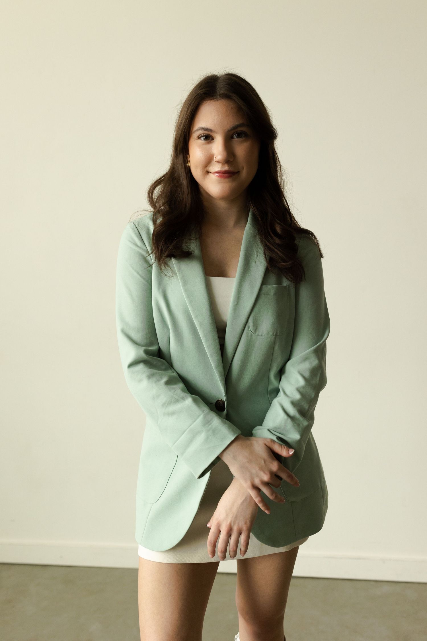 Professional studio portrait in mint green blazer against neutral background showing four similar poses.