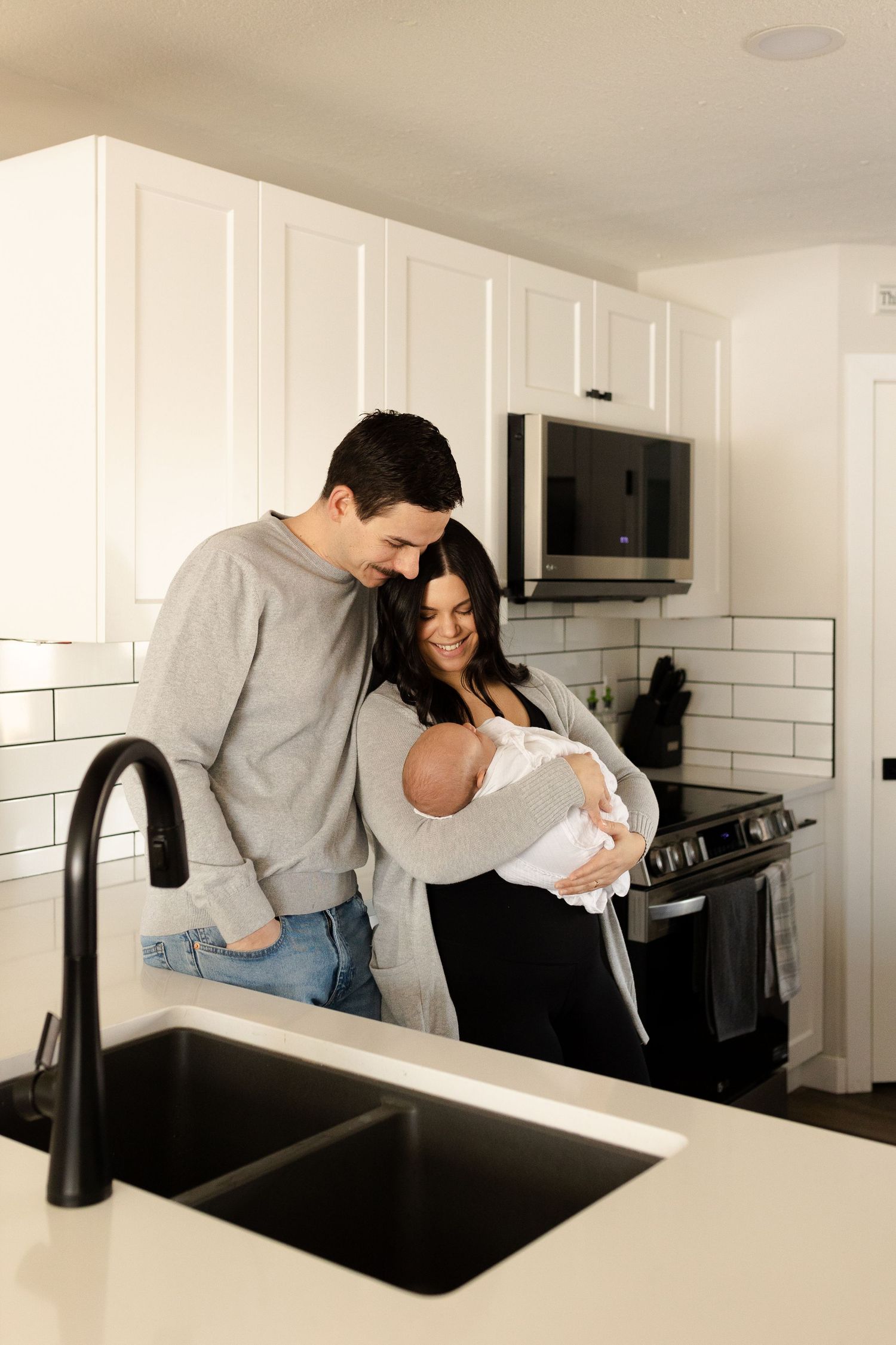 Modern white kitchen with subway tile backsplash during intimate family moments.
