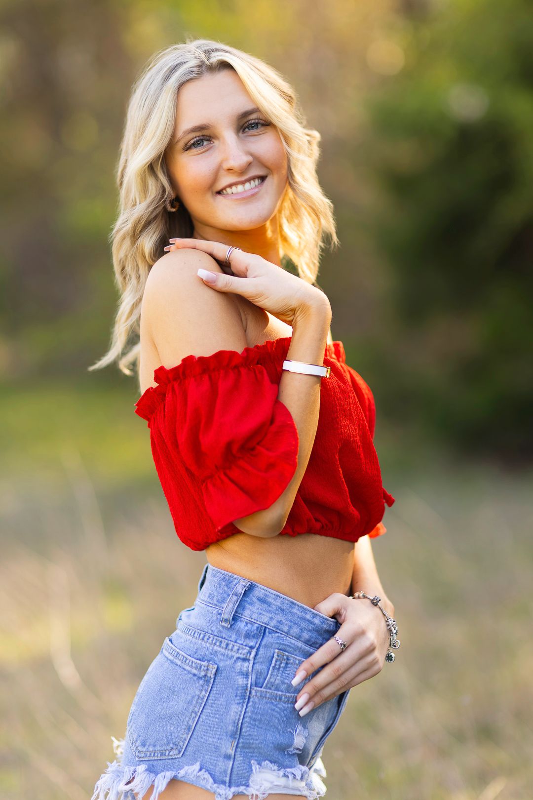 Summer senior portraits in red crop top and denim shorts.  Golden hour sunset lighting. Mckinney Texas.  Erwin Park