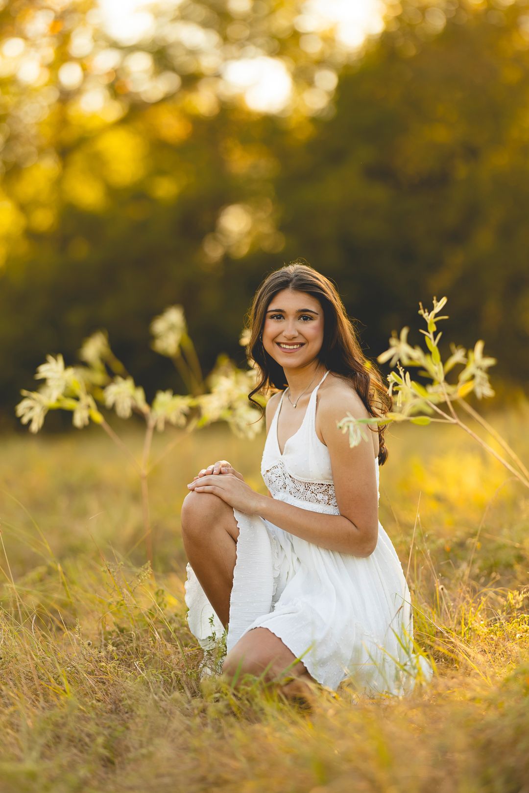 Dreamy outdoor portrait session in a sun-drenched field with tall grass.
