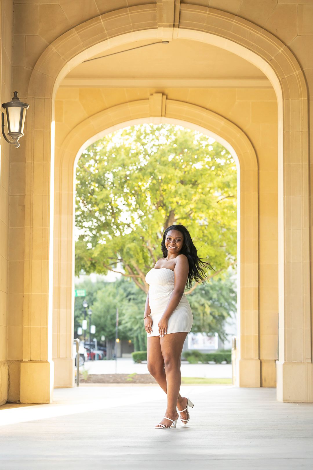 Architectural portrait session under cream arches and natural lighting.