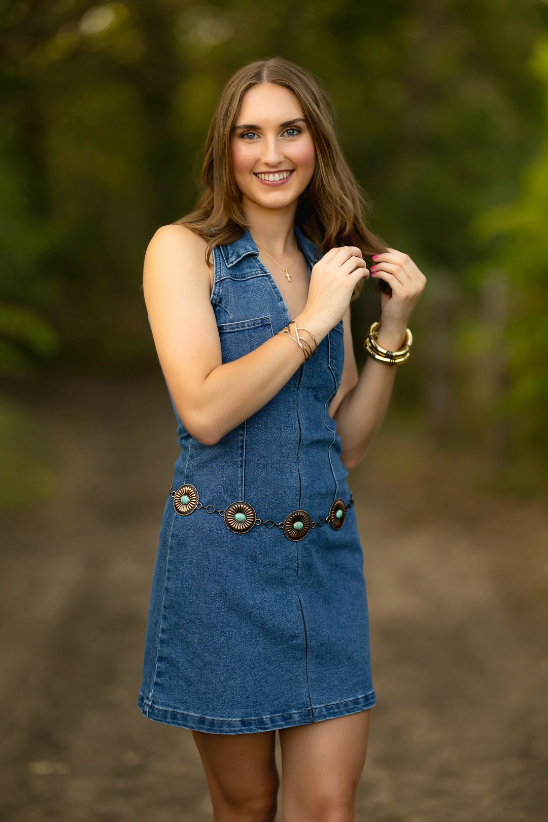 Fashion portraits in denim dress against natural outdoor background during sunset.