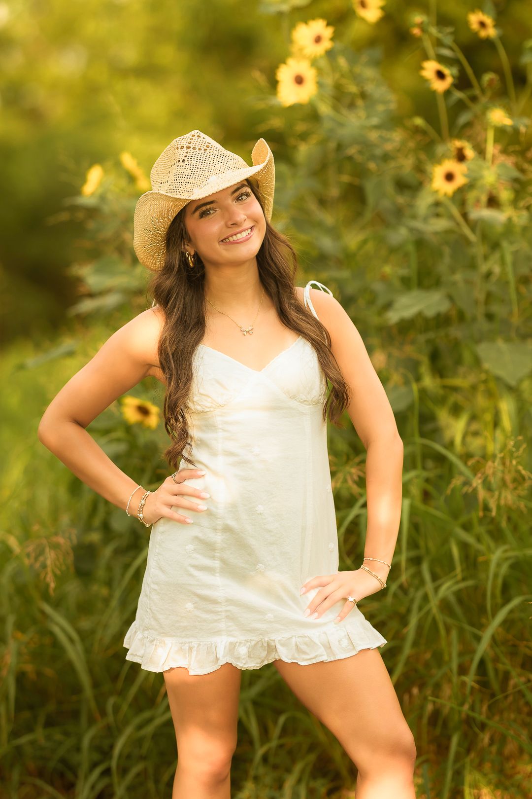 Summer portrait series with sunflowers featuring a white top and straw hat.
