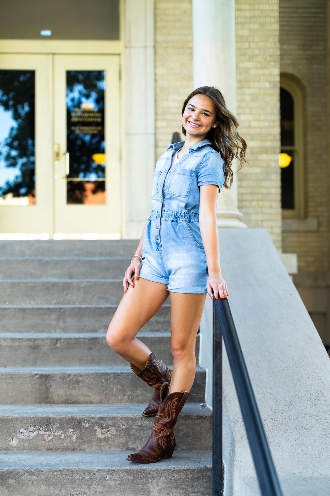 Portrait series on concrete steps featuring denim romper and brown cowboy boots.