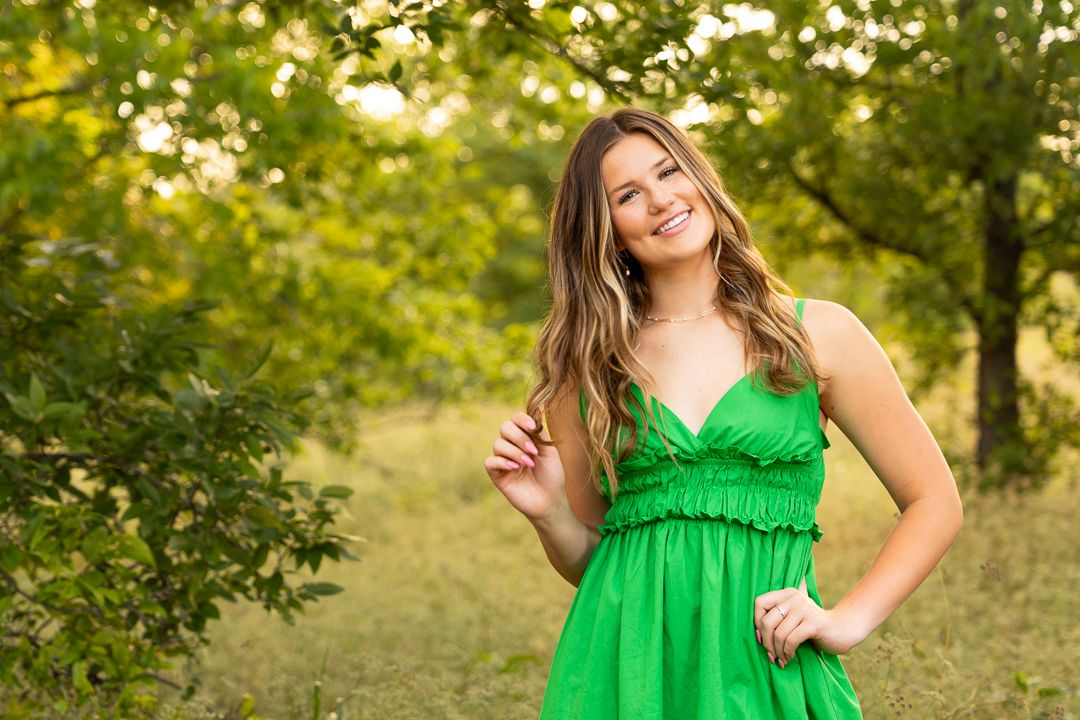 Outdoor lifestyle photos in emerald green sundress against natural scenery.