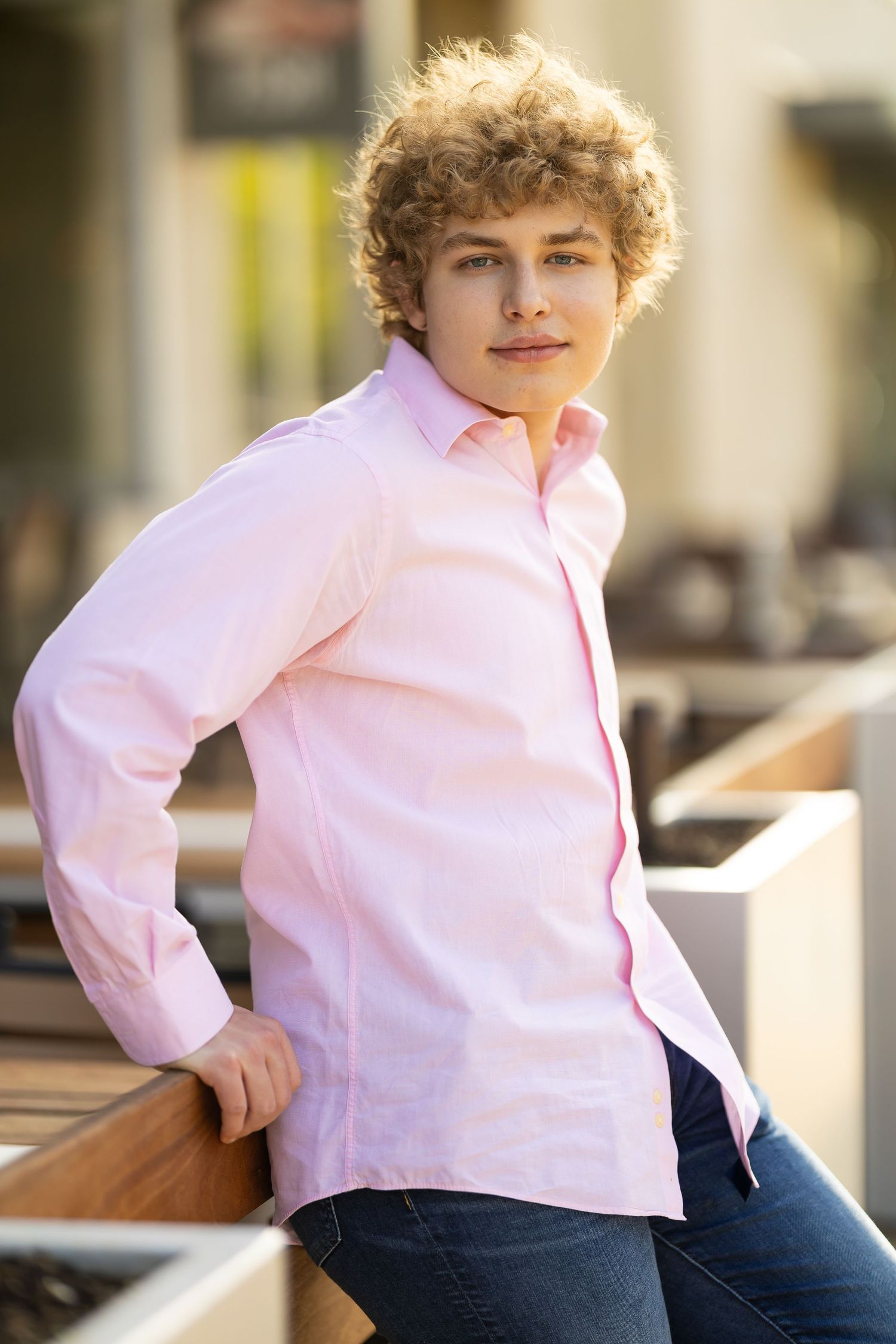 A series of four connected photos showing someone in a pink shirt and jeans sitting casually on outdoor steps.