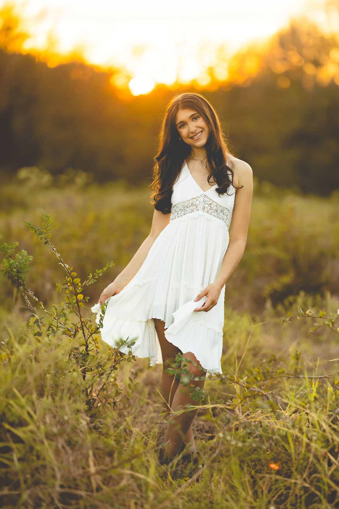White dress photographed against golden sunset light in wild grass.