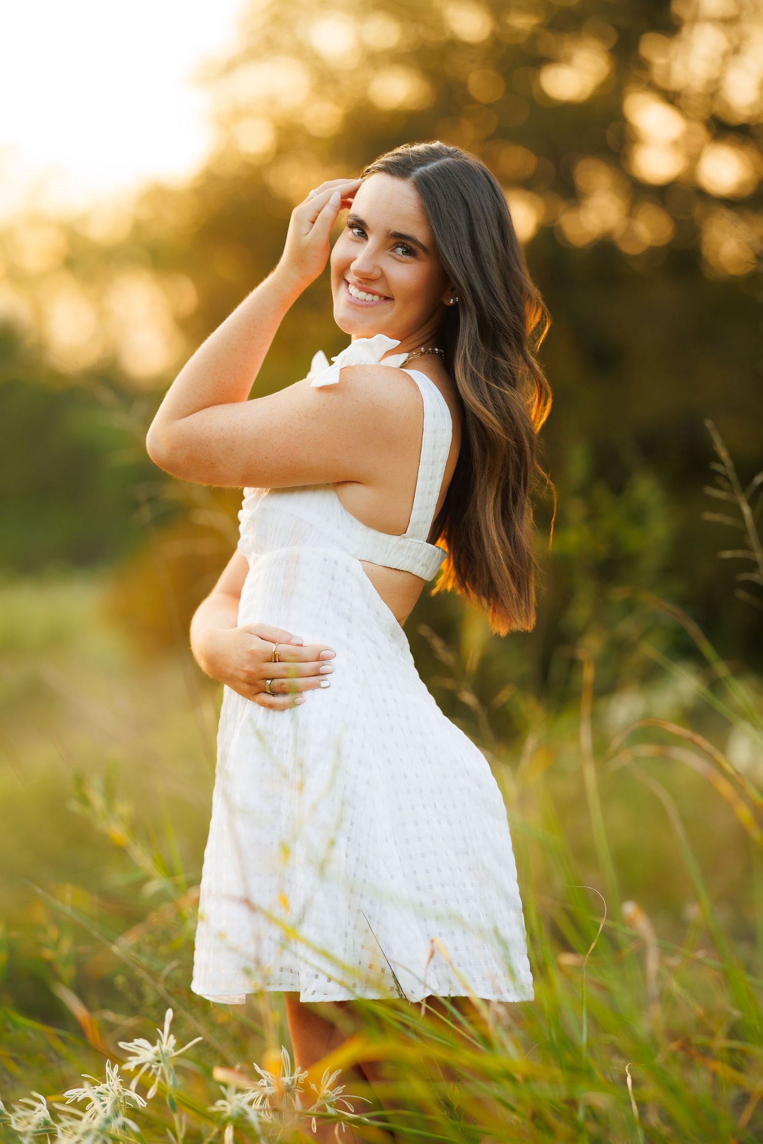 White sundress portrait session in golden field during sunset.