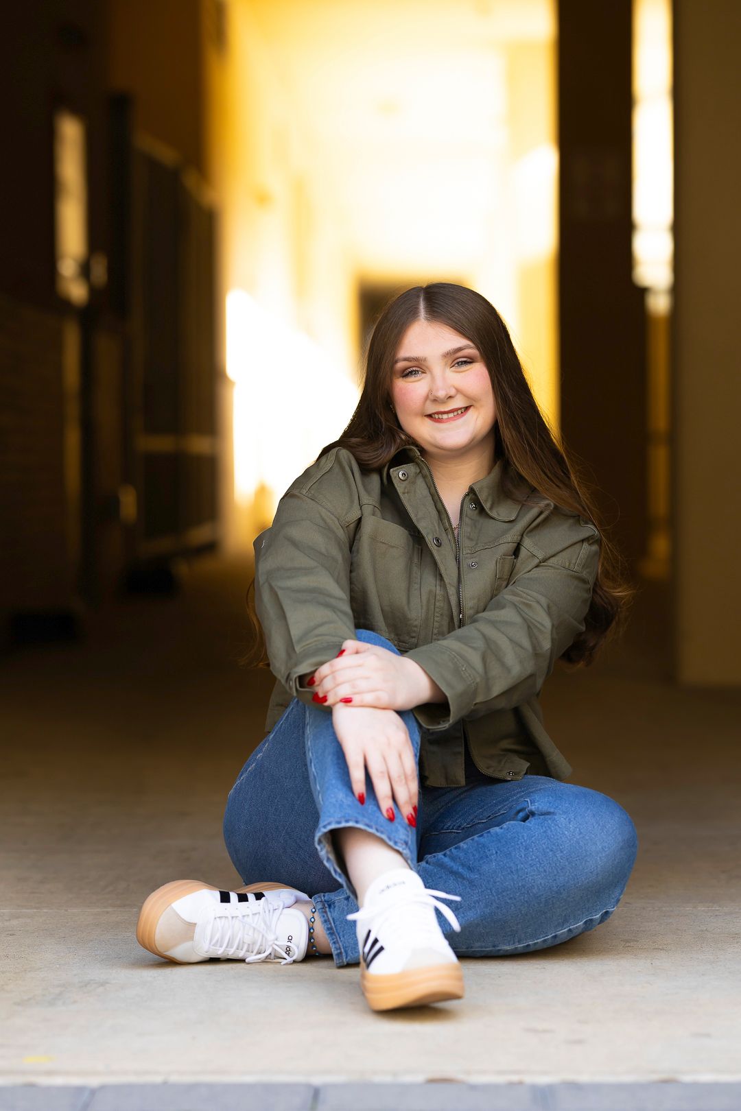 Casual indoor portrait session with olive jacket and jeans.