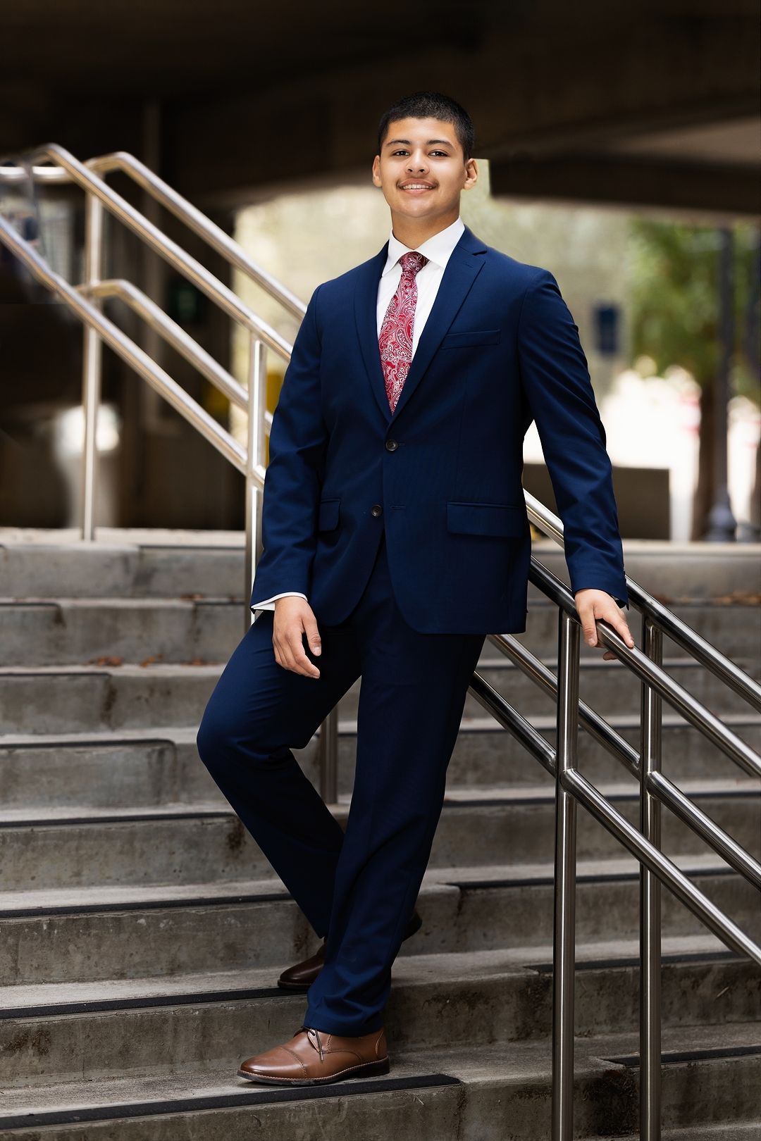 Professional portrait series showing formal attire and poses on concrete steps with metal railing.