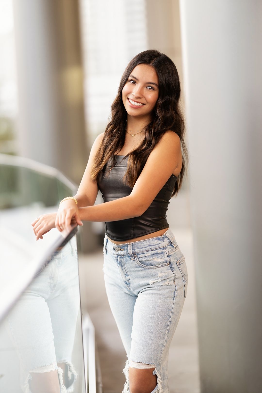 A casual summer outfit featuring light wash denim shorts and a dark crop top in a bright indoor setting.