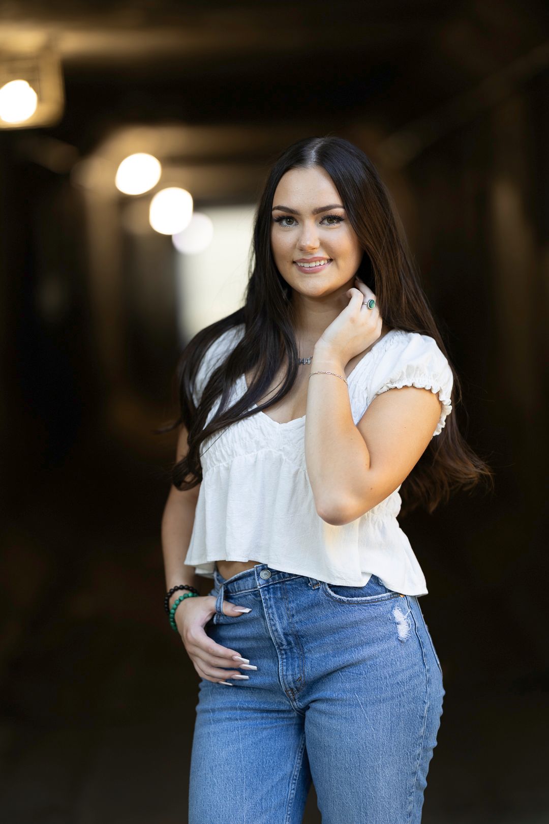 Classic white top and blue jeans combination in dimly lit setting.