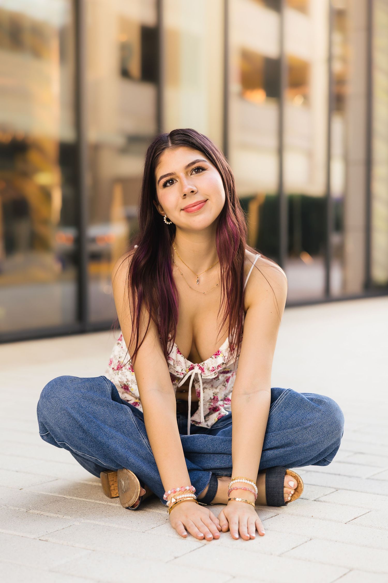 A woman in casual attire poses on a concrete floor in a series of relaxed positions.