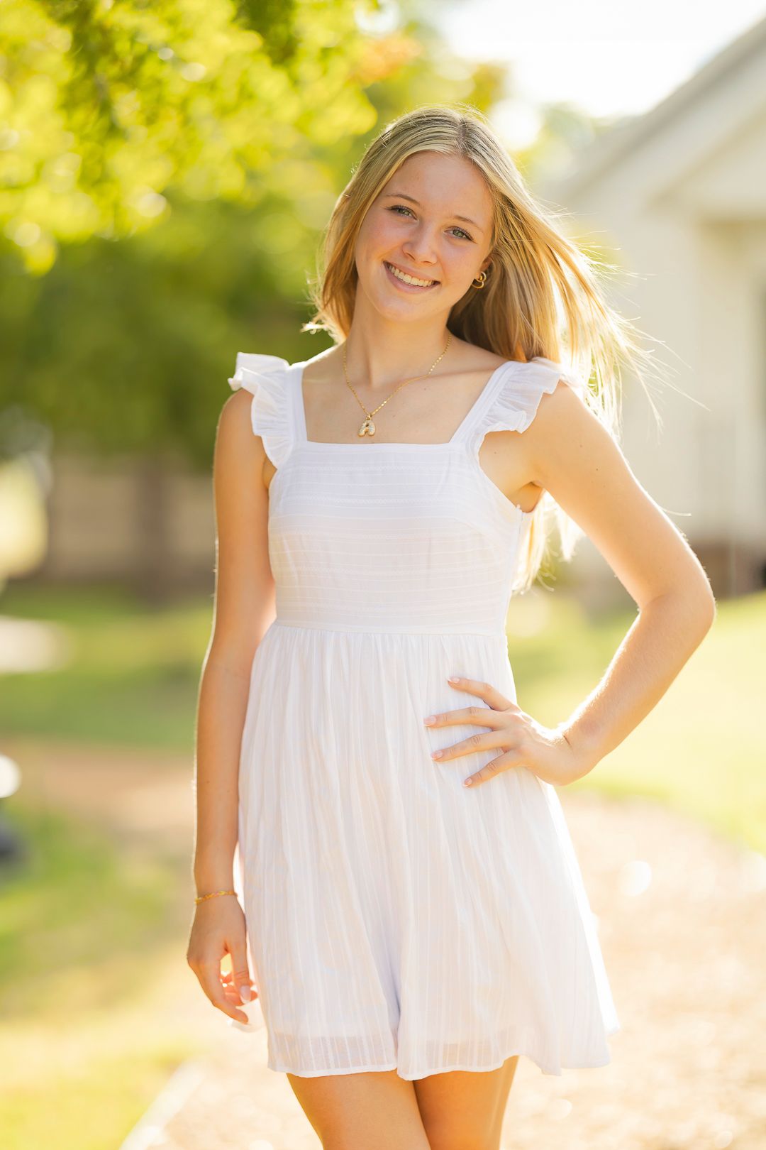 Sunlit portrait in white summer dress during golden hour.