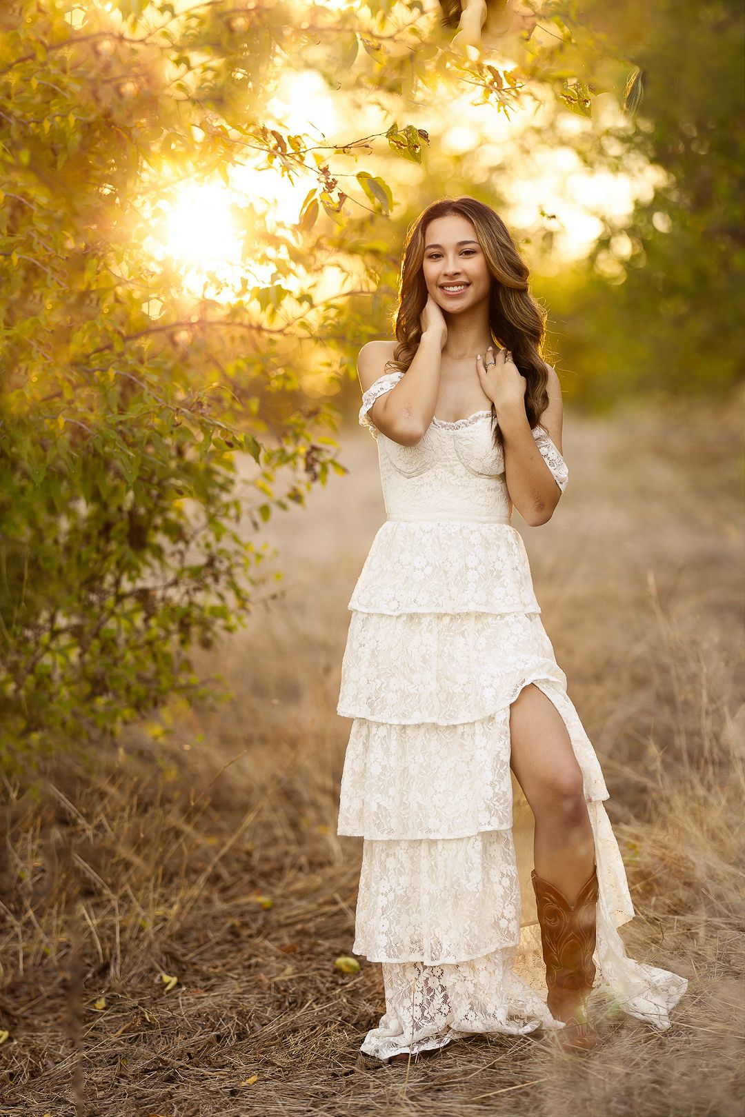 Dancing in a white lace dress during golden hour in a natural outdoor setting.