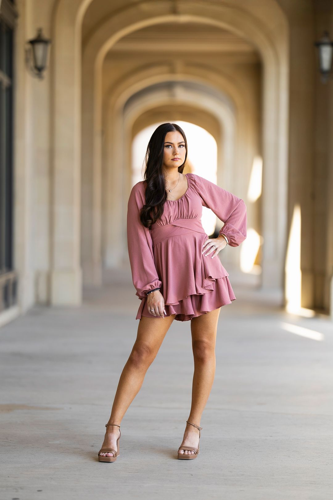 Mauve flowy top photographed in elegant archway setting with natural lighting.