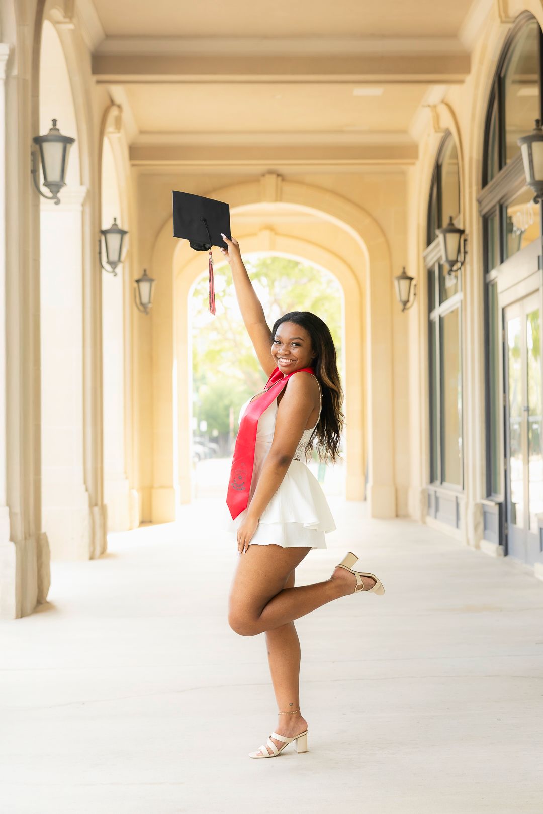Elegant dance poses captured in sunlit colonial-style archway.
