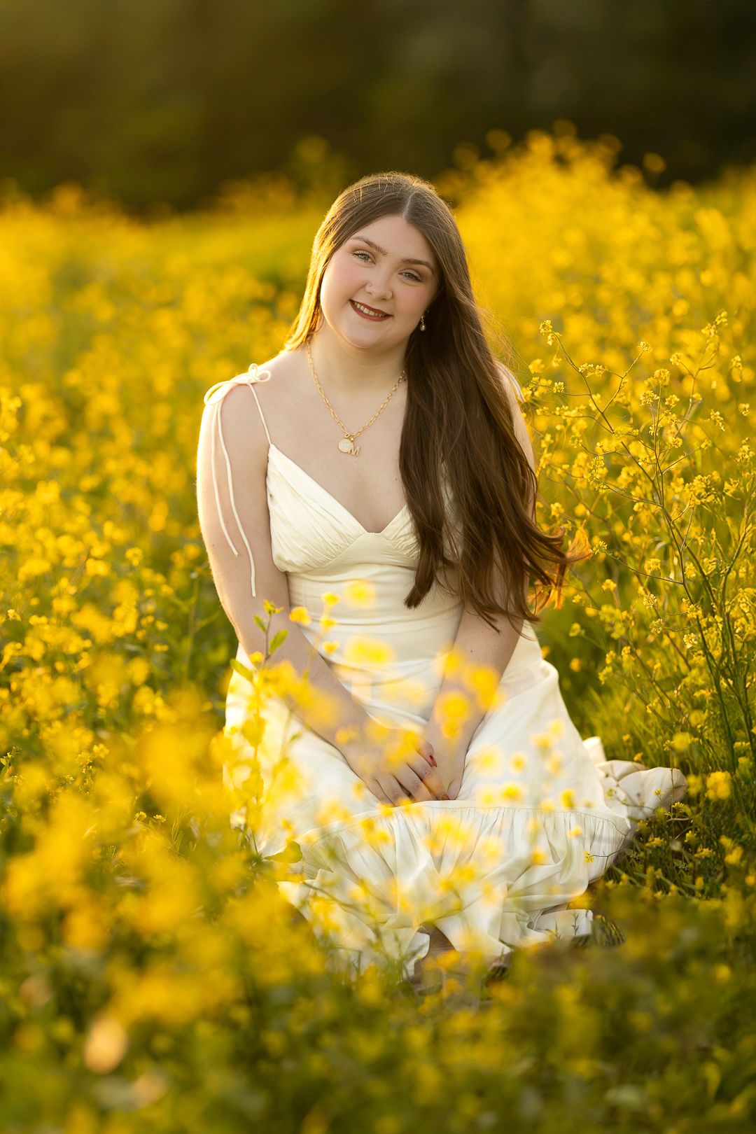 A white sundress contrasts beautifully against a field of bright yellow wildflowers in golden sunlight.