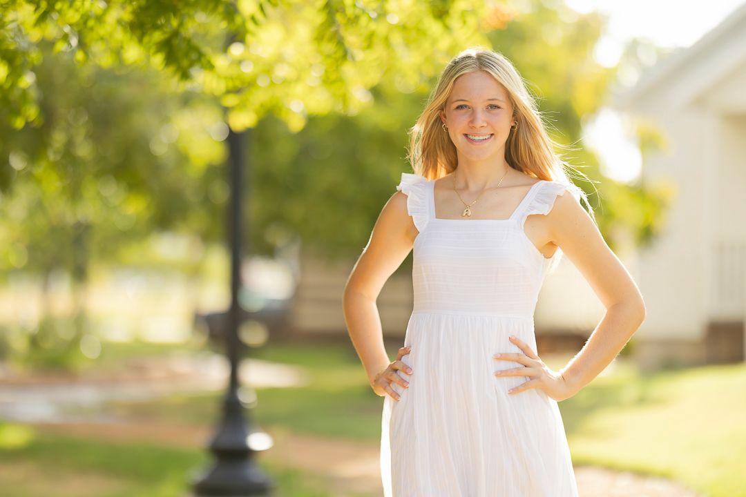 Outdoor summer portrait in white dress with natural backlight.