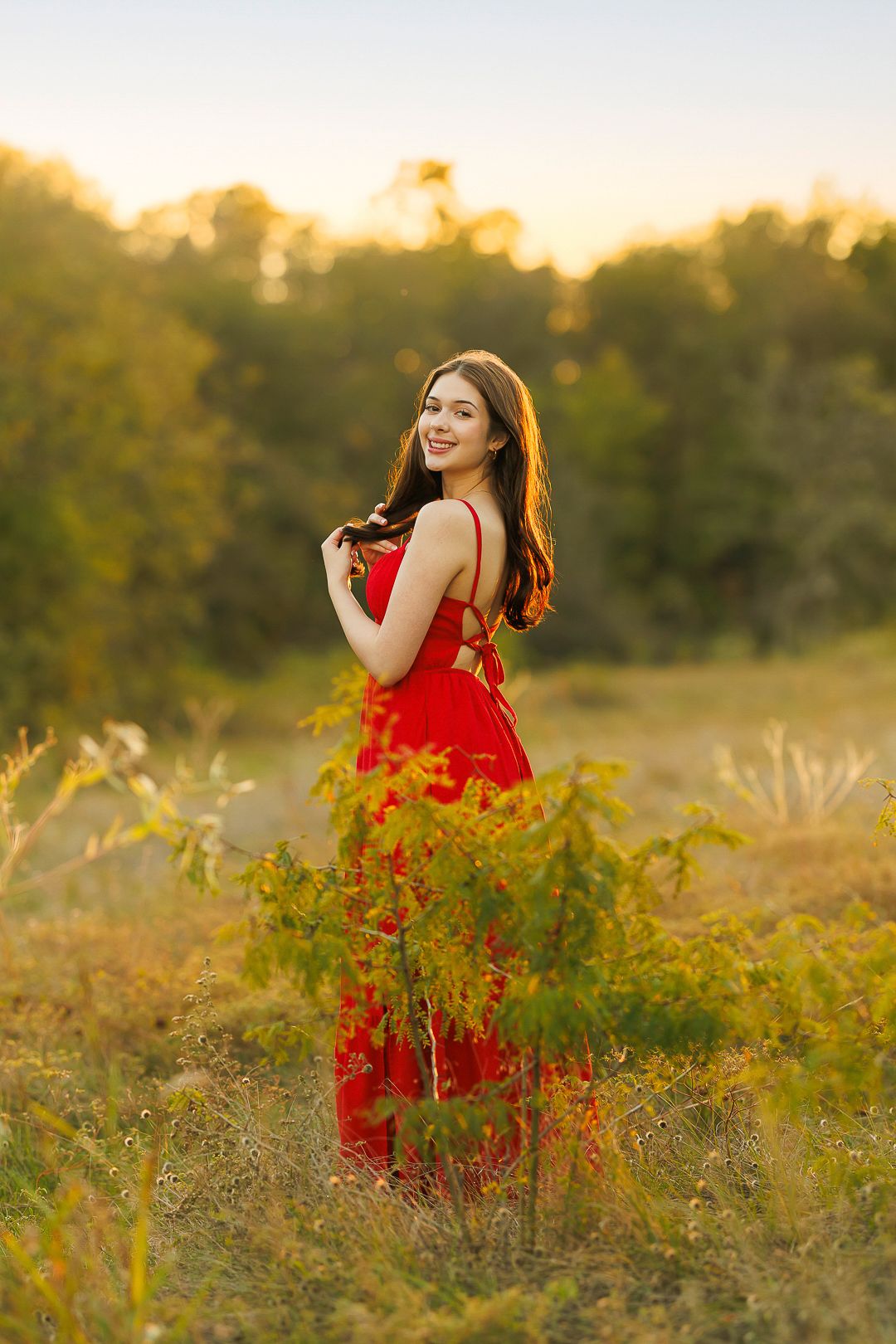 Sunset portrait session in a wildflower field wearing vibrant red.