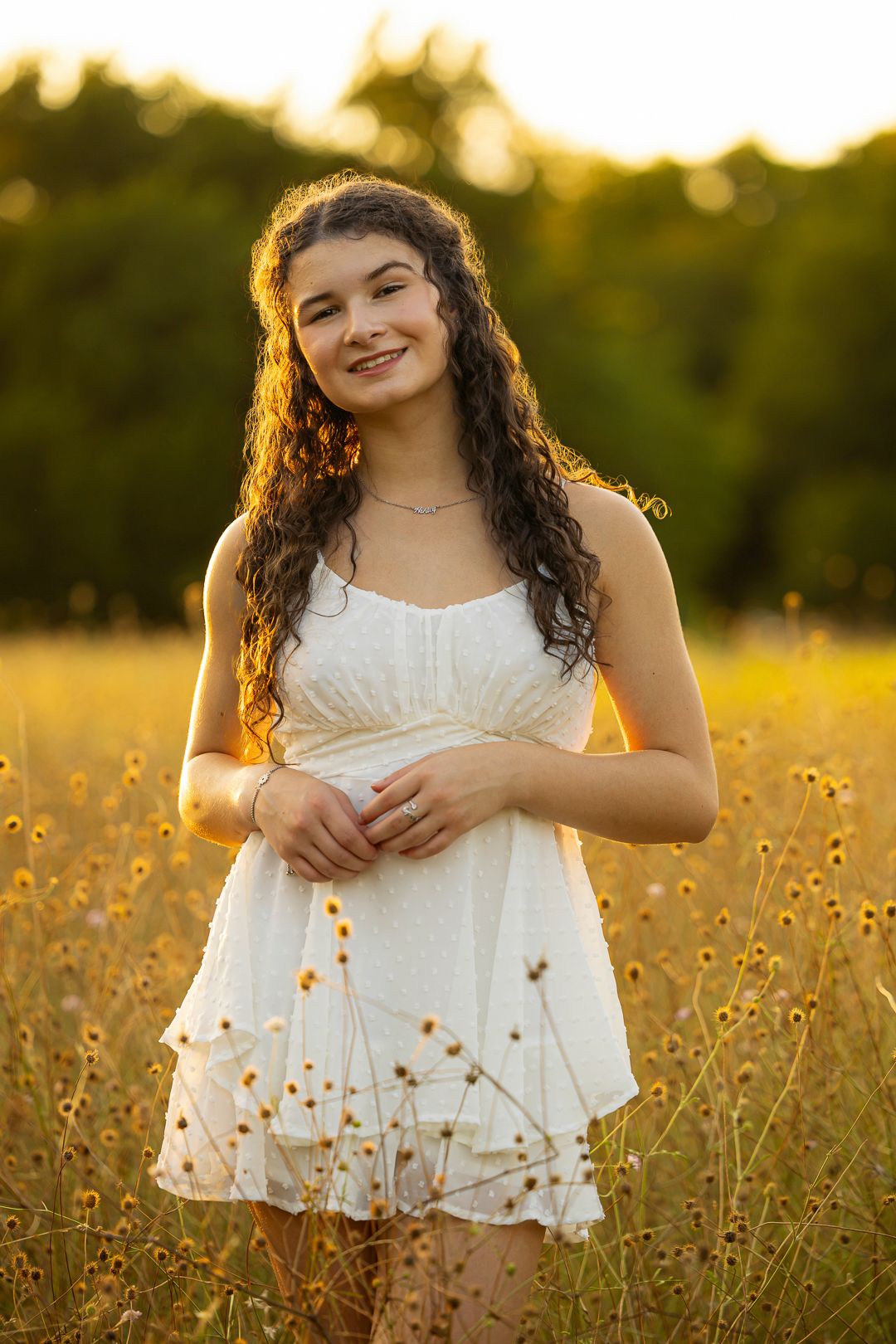 Dreamy summer photoshoot in white dress among wildflowers at sunset.