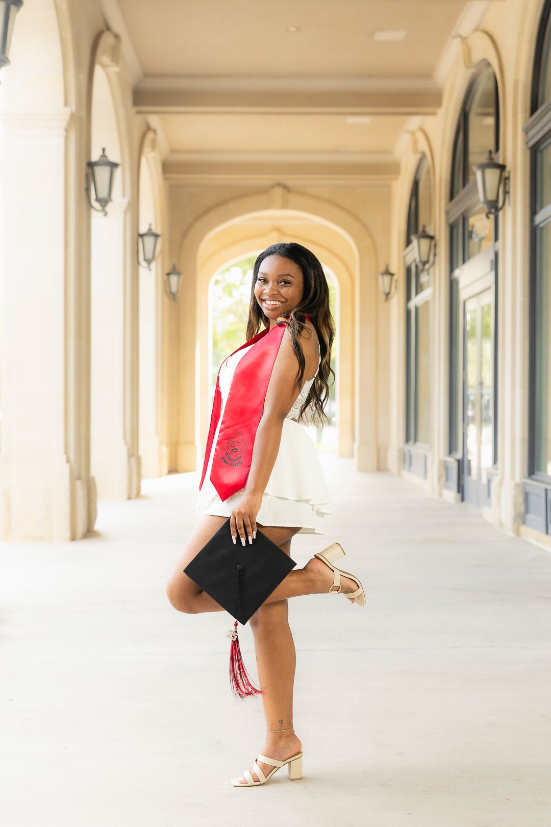 Red top and black shorts ensemble photographed in elegant arched colonnade.