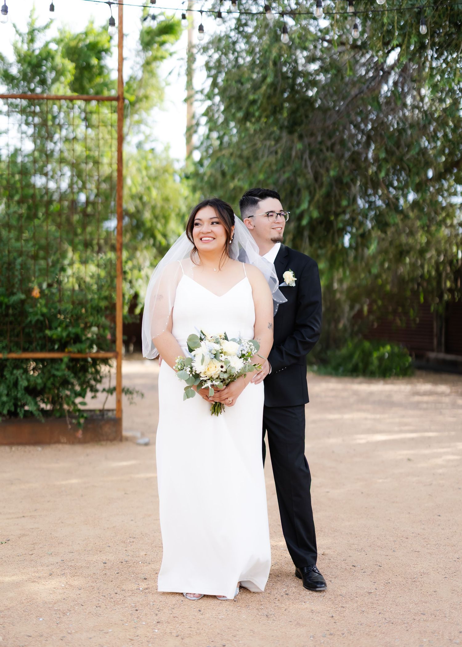 Wedding ceremony setup in a garden with lush greenery backdrop.
