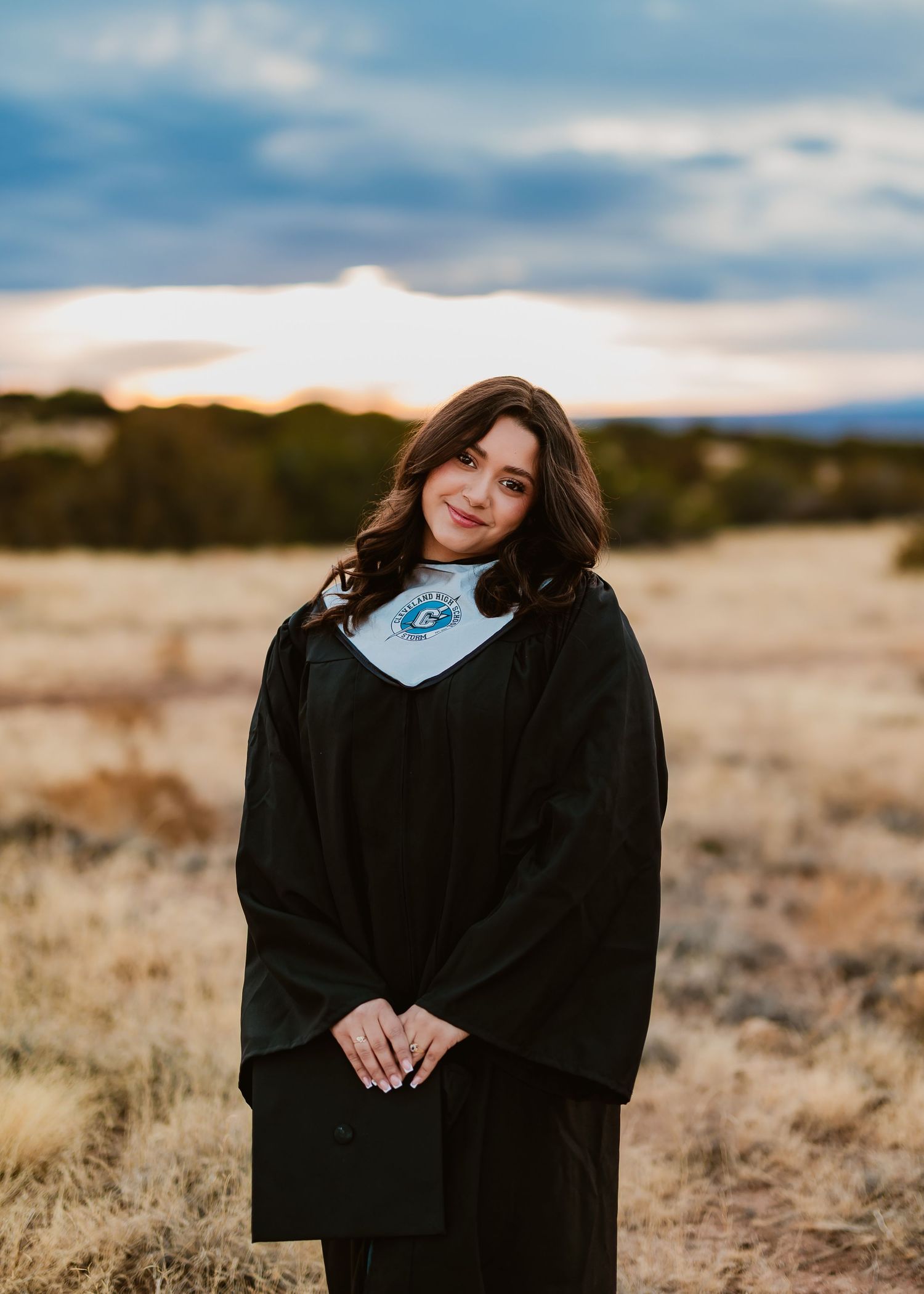 Person wearing a black sweater poses in a golden field during an outdoor portrait session.