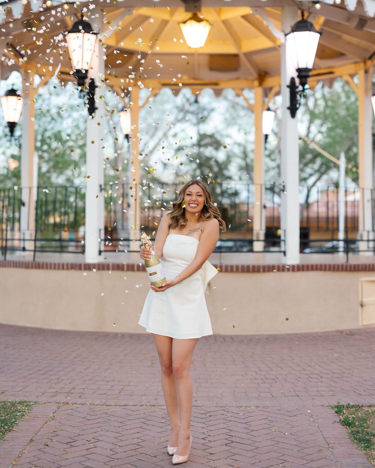 A decorated outdoor pavilion with twinkling lights and white columns creates a romantic wedding venue atmosphere.