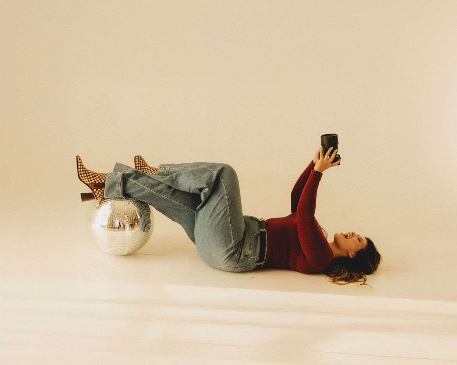 Series of six minimalist studio photos showing a person lying down on a white floor in casual grey clothing.