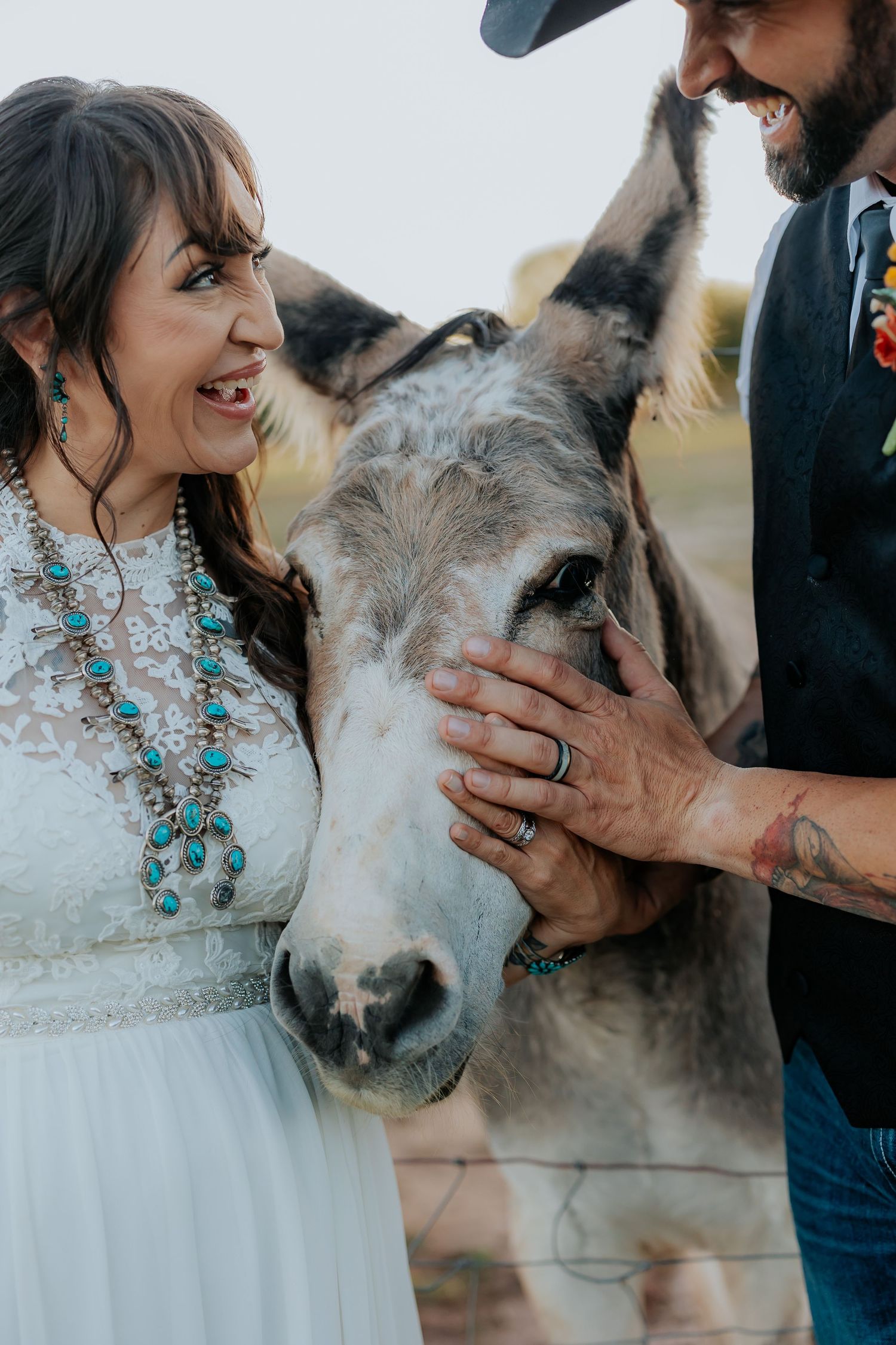 Sweet interaction with a friendly donkey at a rustic outdoor wedding.