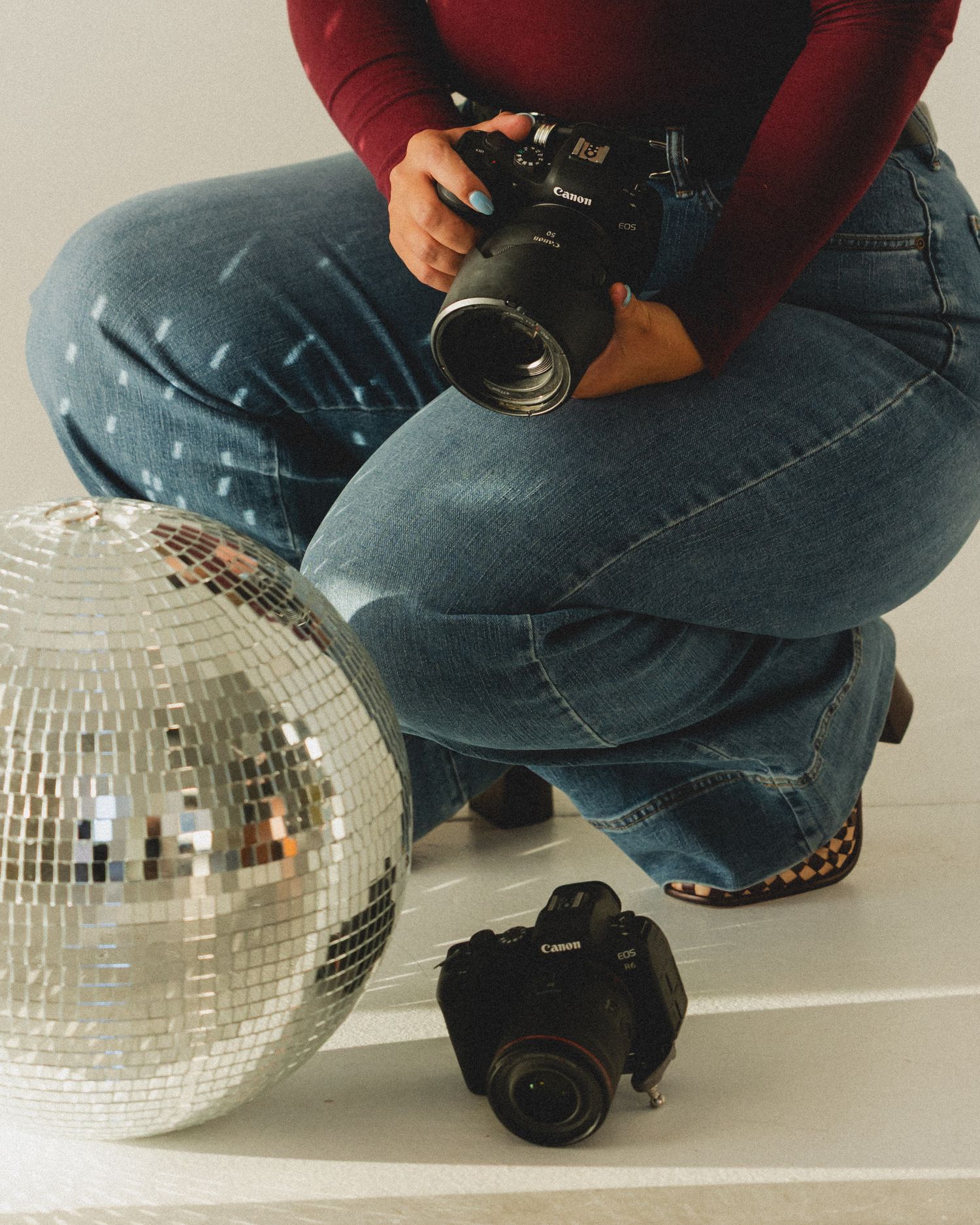 Close-up shots of a disco ball and camera equipment arranged on a white surface.