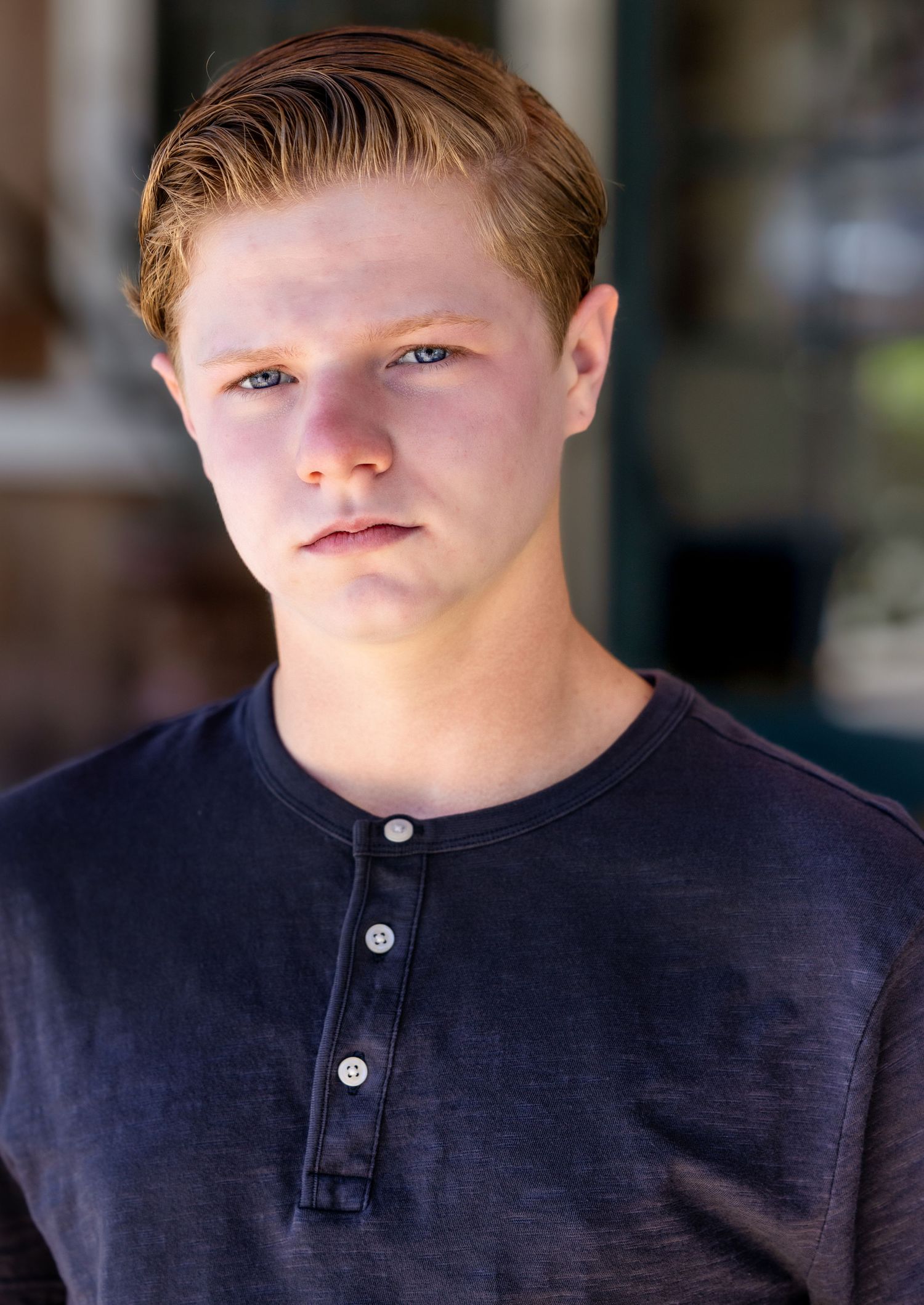 Close-up portraits in navy henley shirt showing natural expressions.