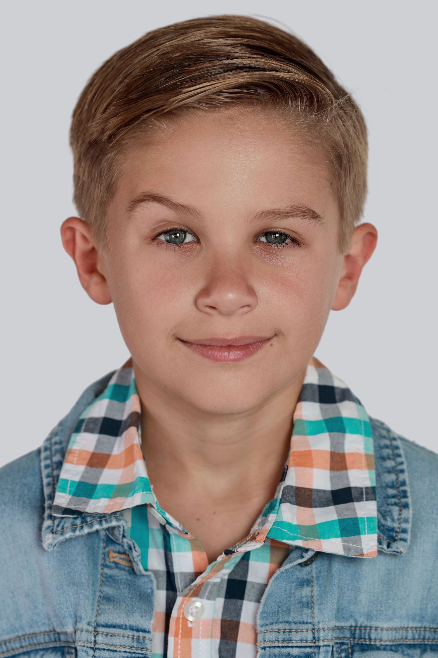 Young model in denim jacket and plaid shirt shows playful expressions in headshot photo series.