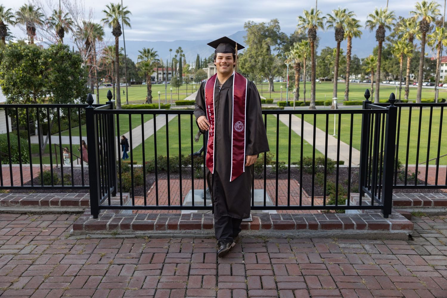 A series of graduation photos showing someone in academic regalia posing with palm trees and a brick pathway on campus.