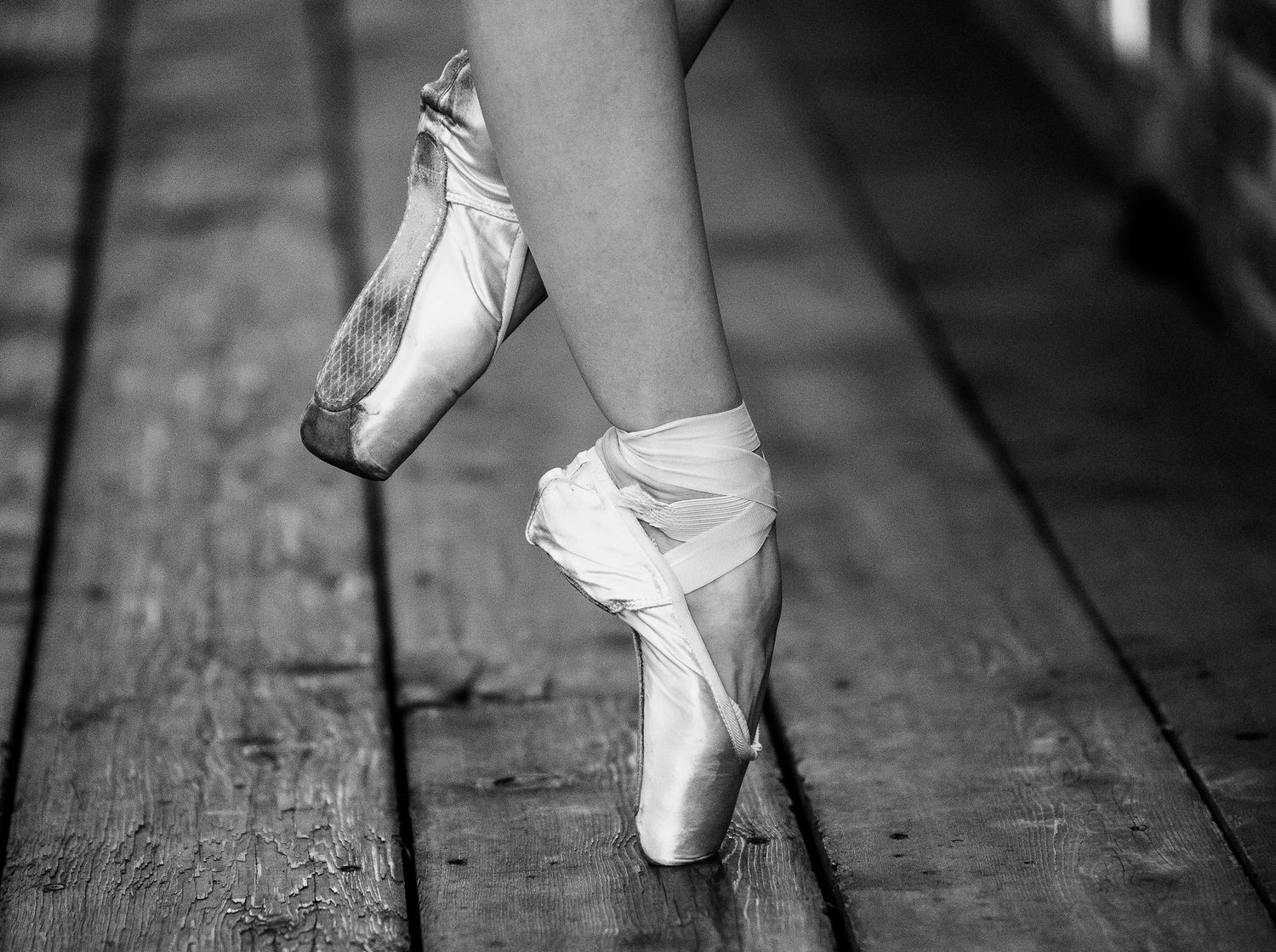 A series of black and white photographs showing ballet shoes and feet in various dance positions on wooden floors.
