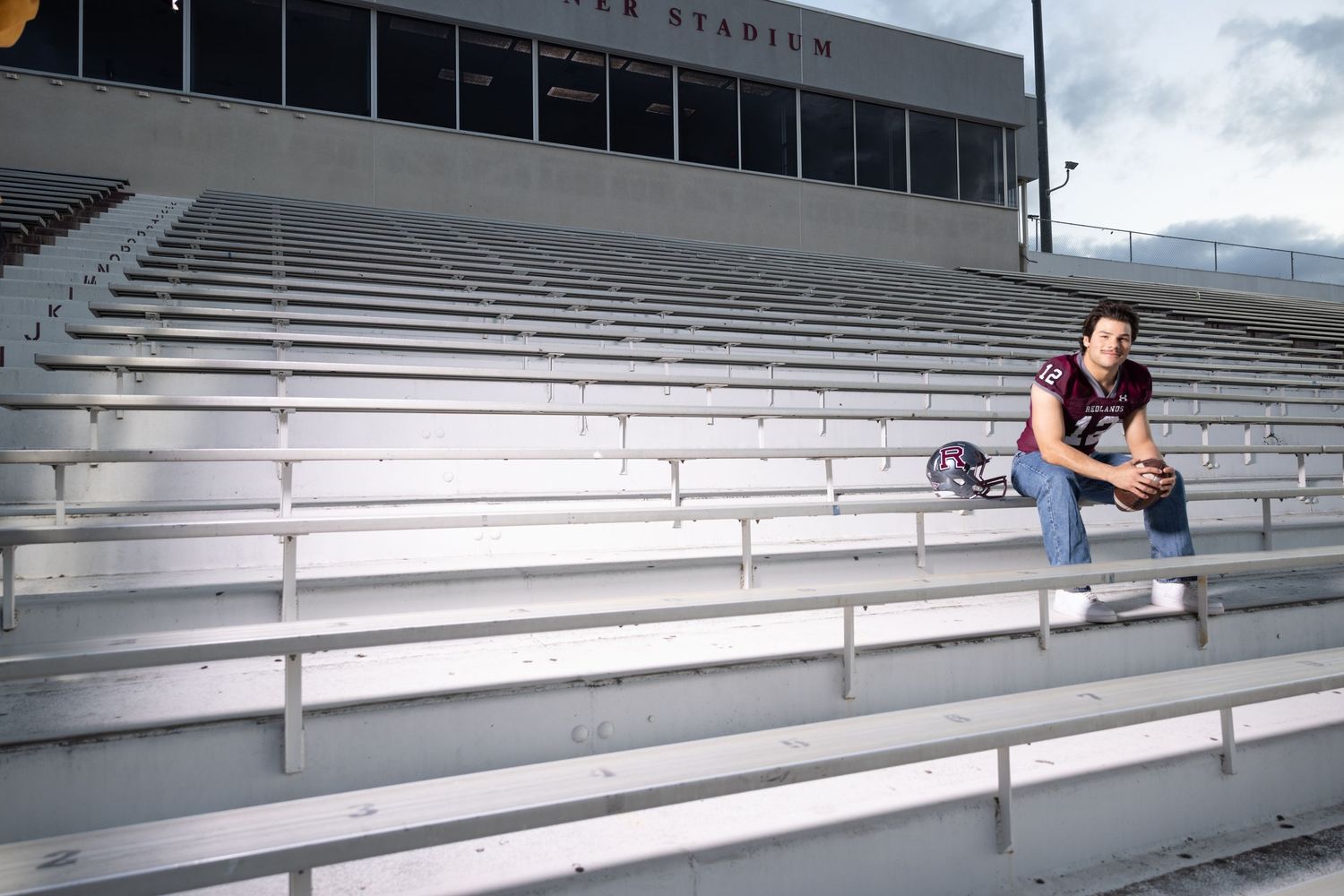 Person skateboarding down a large concrete staircase in a stadium or amphitheater setting.