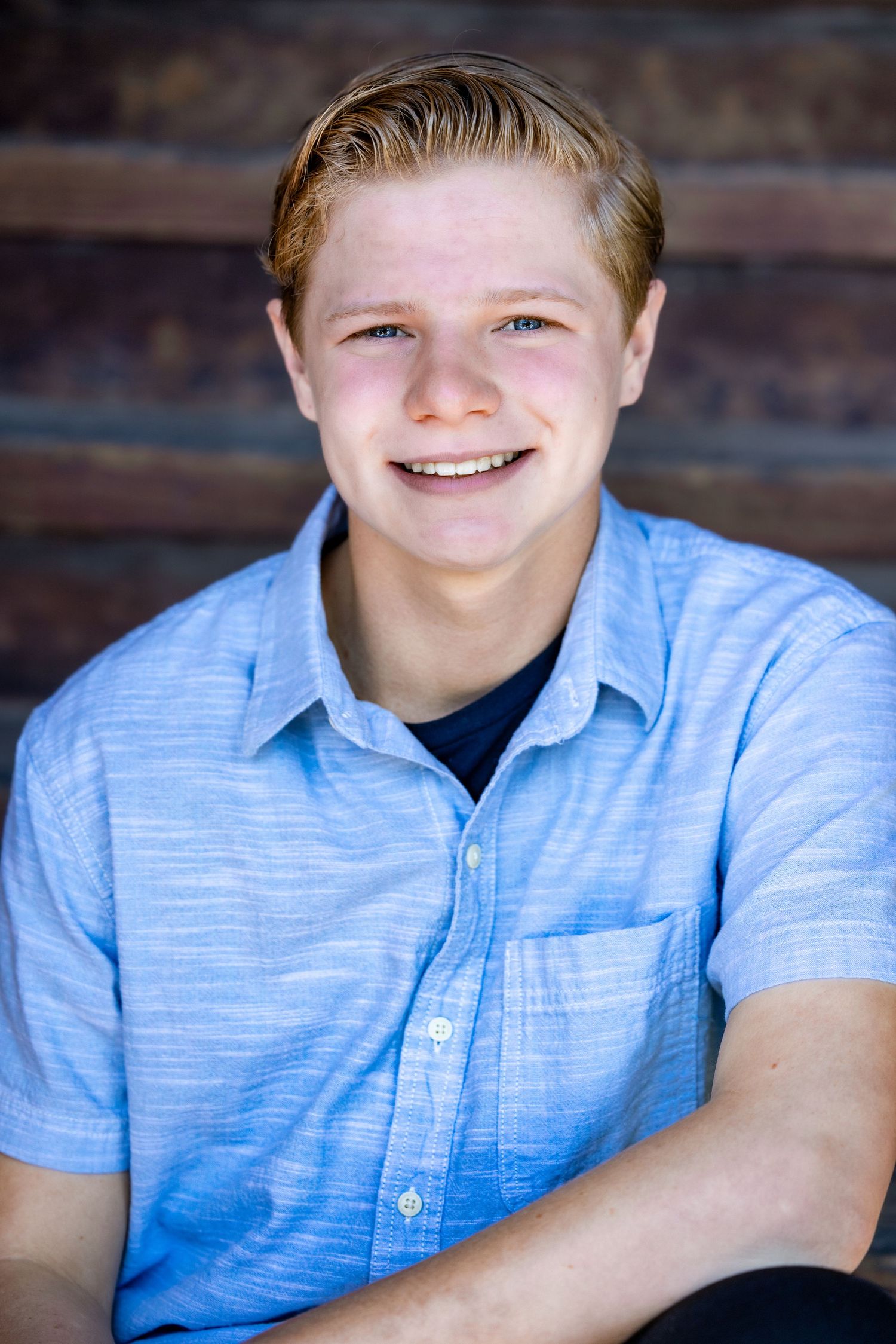 theater kid headshot. Headshot series in light blue button-down shirt showing friendly expressions.